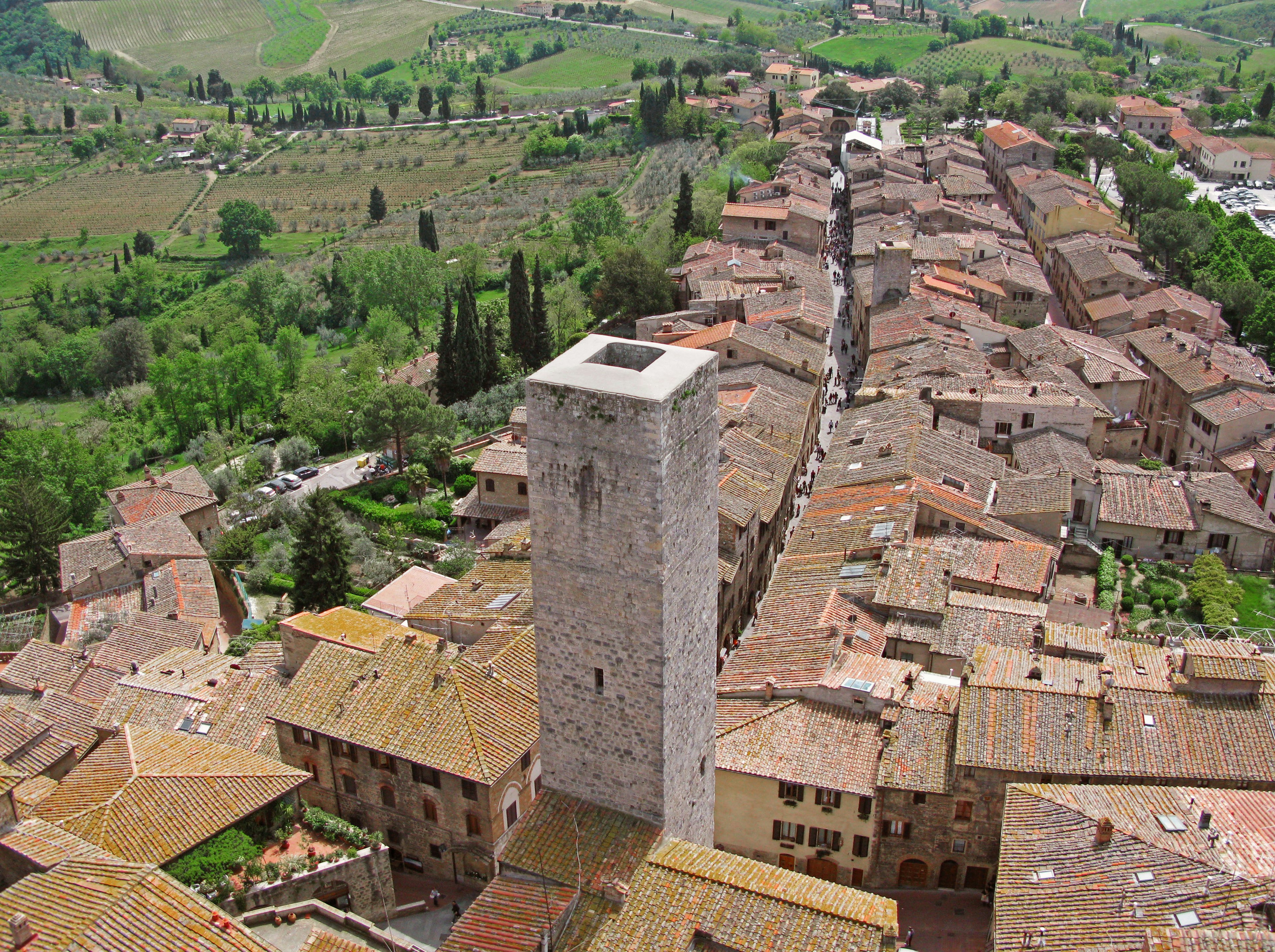 Aerial view of San Gimignano showcasing medieval architecture with a tall stone tower and terracotta rooftops