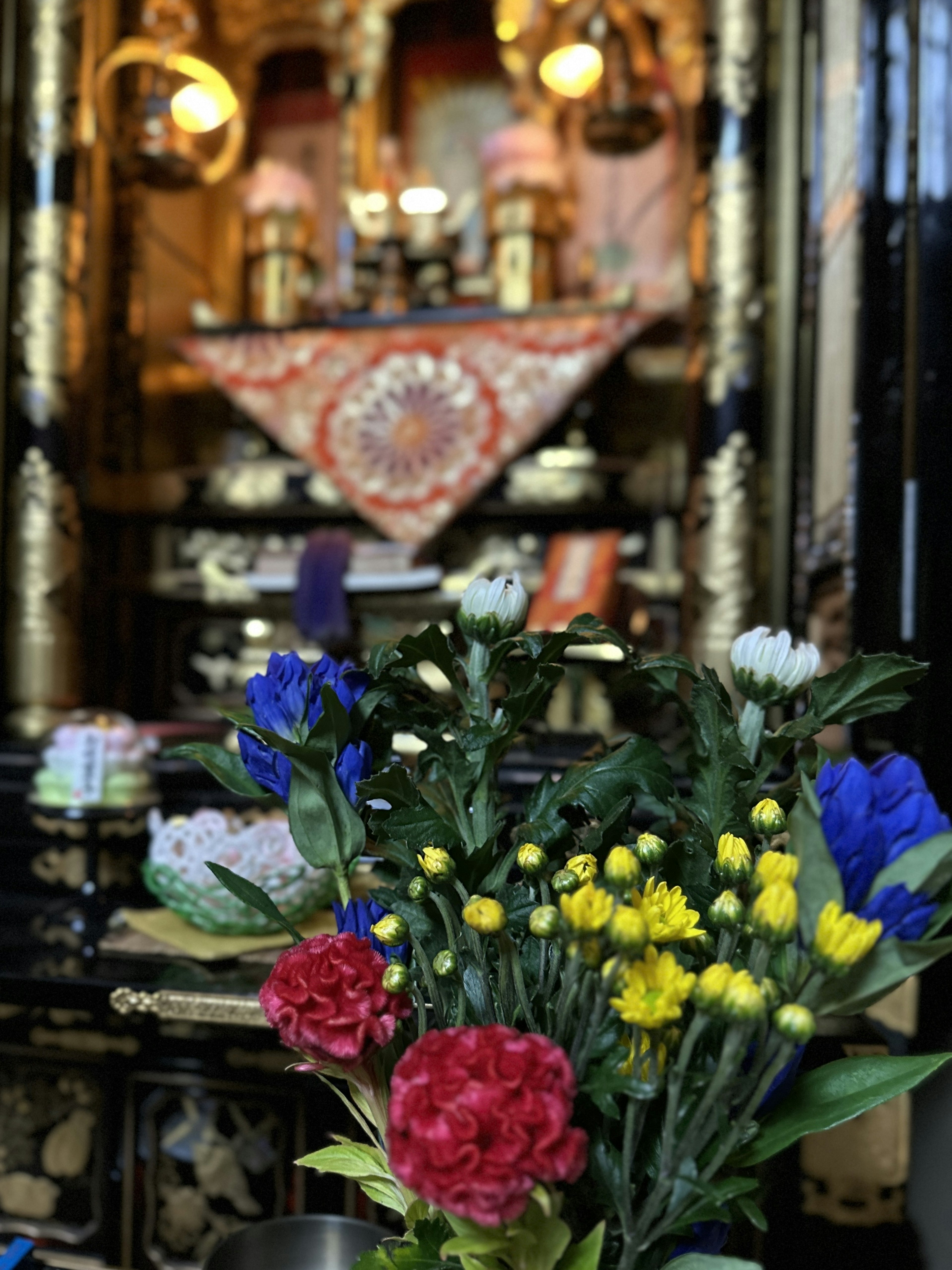 Rangkaian bunga berwarna-warni di depan altar yang didekorasi dengan indah dengan aksen emas