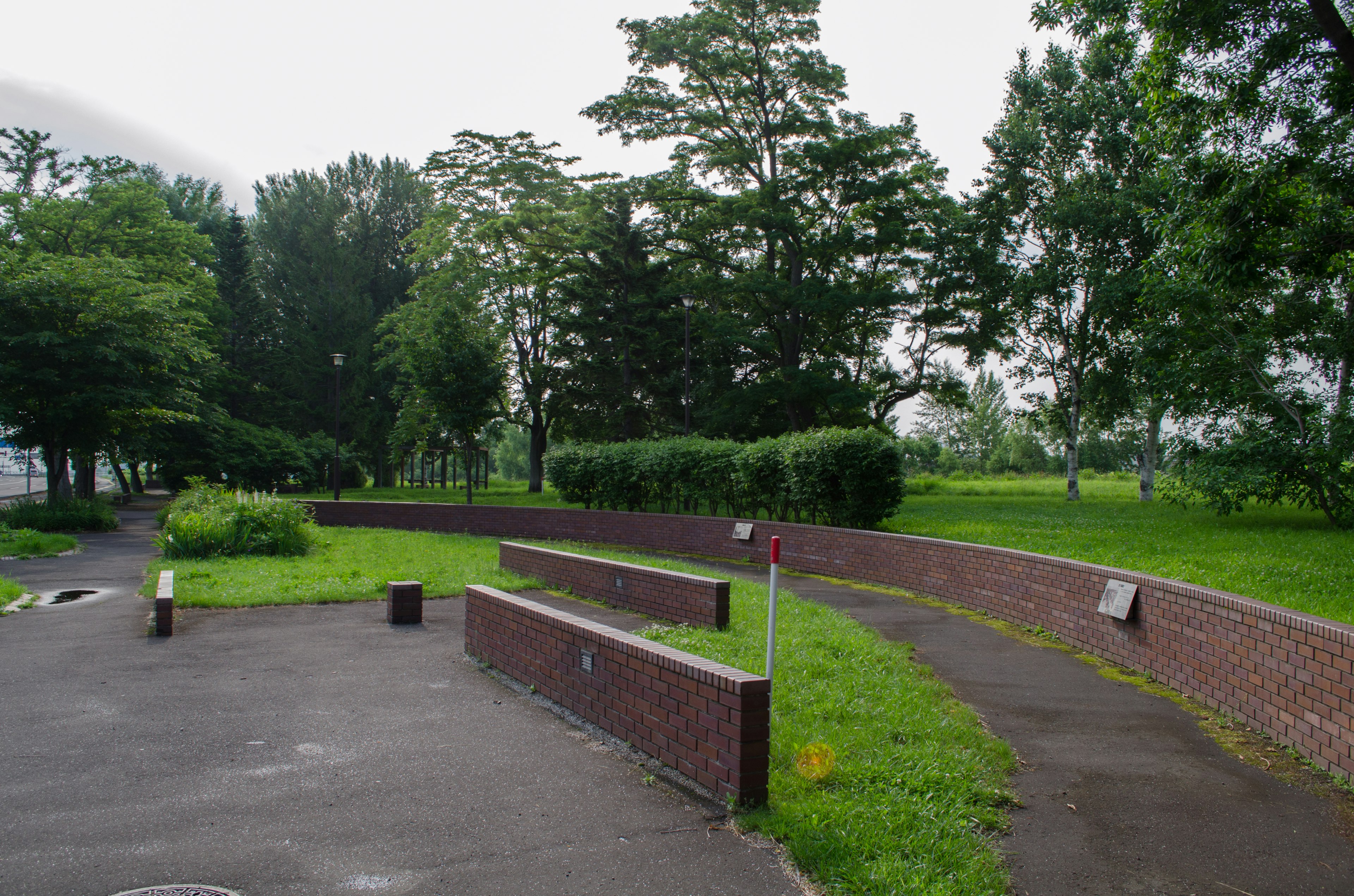 Lush park landscape featuring curved brick benches