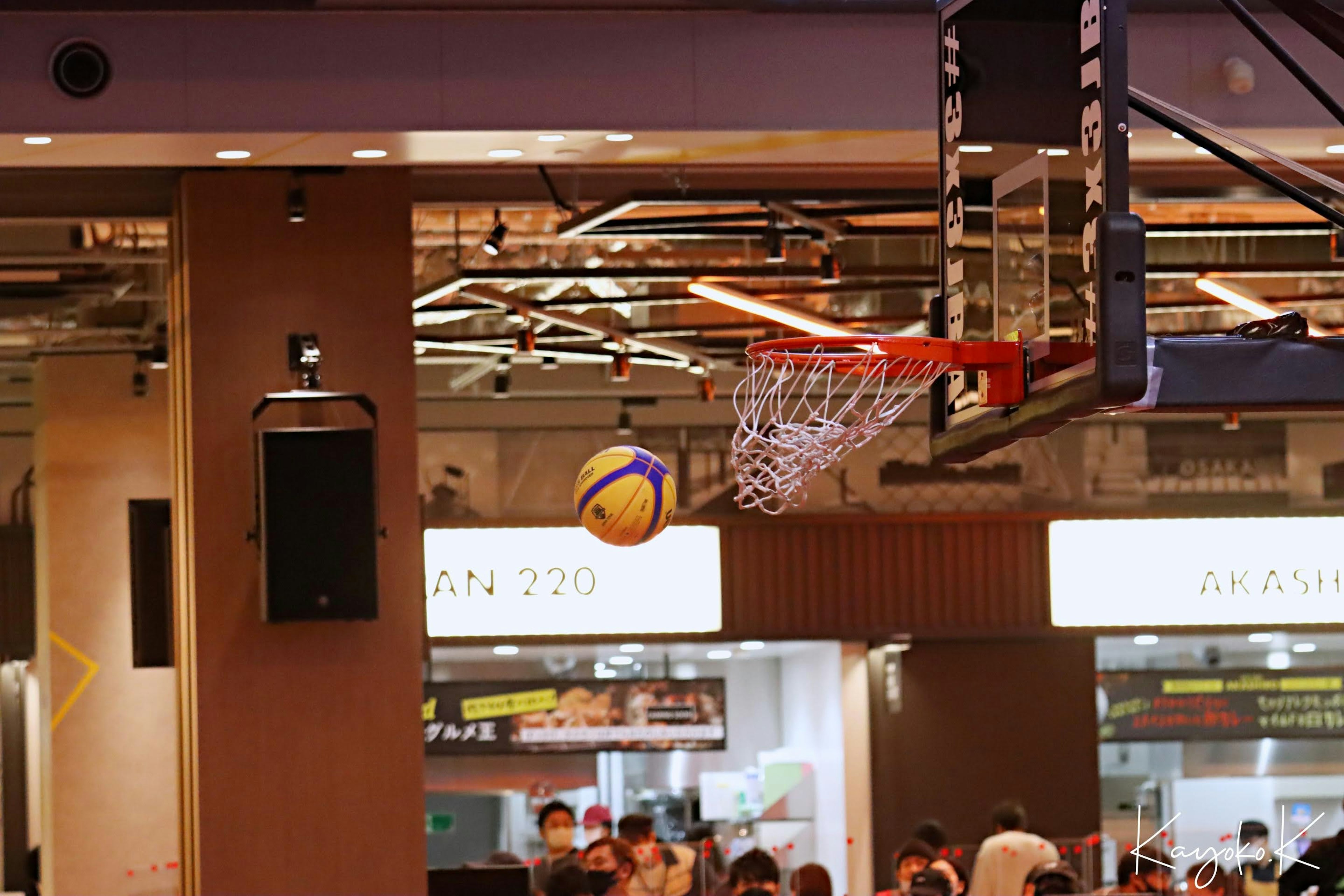 Scène intérieure avec un ballon de basket volant vers le panier