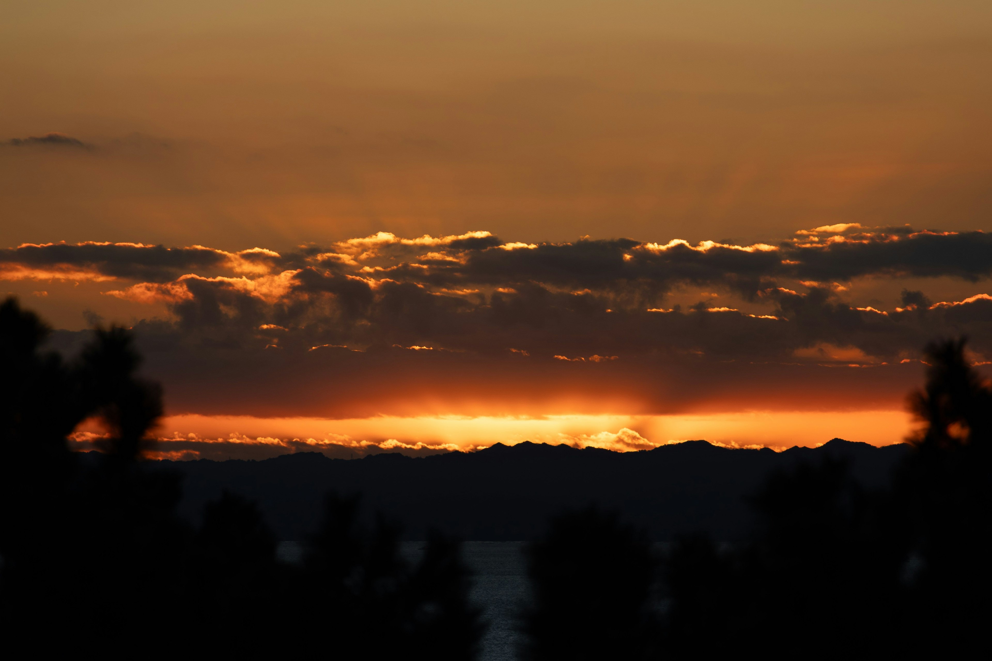 夕焼けの美しい風景 山々のシルエットとオレンジ色の空