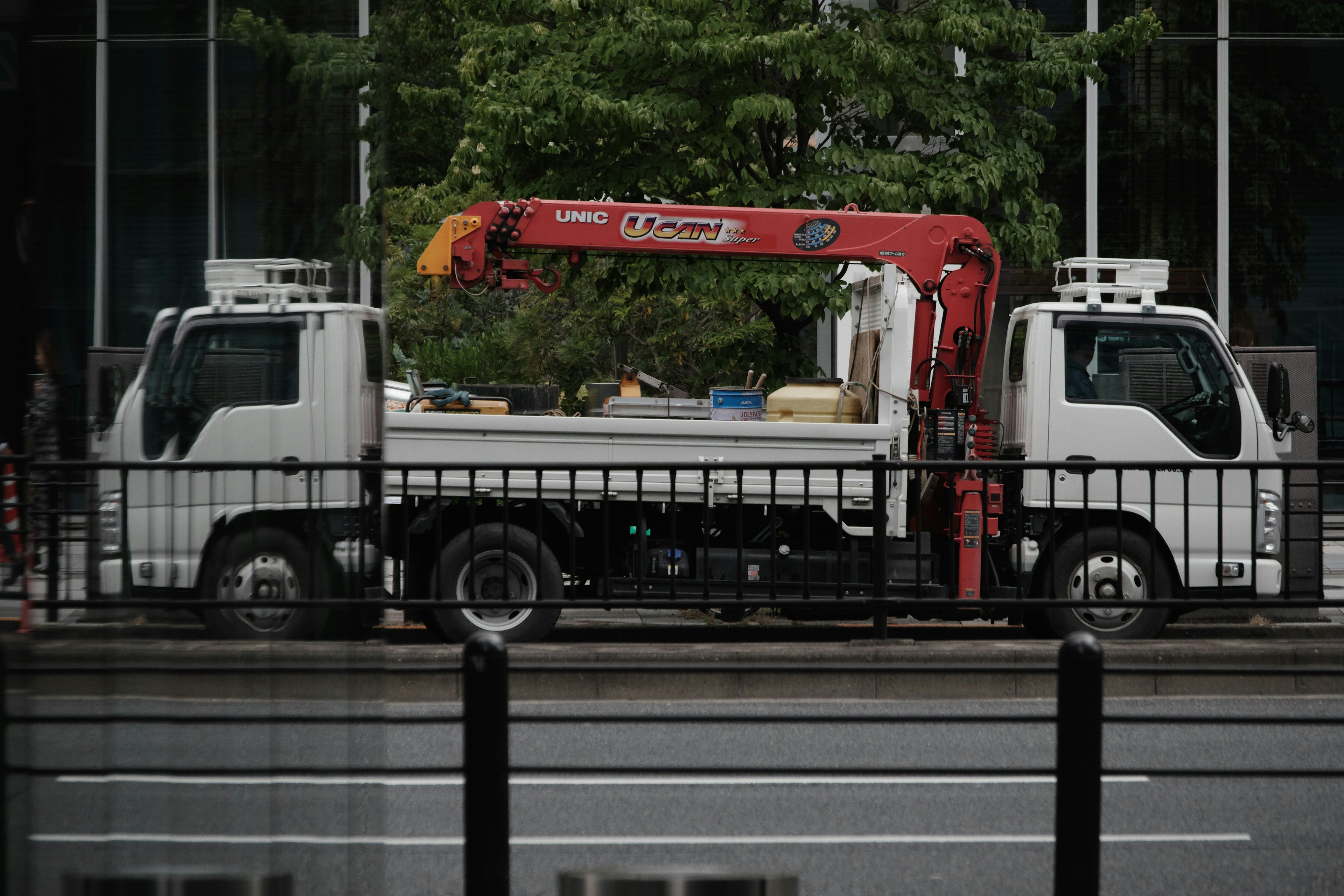 A white truck with a red crane parked in the city