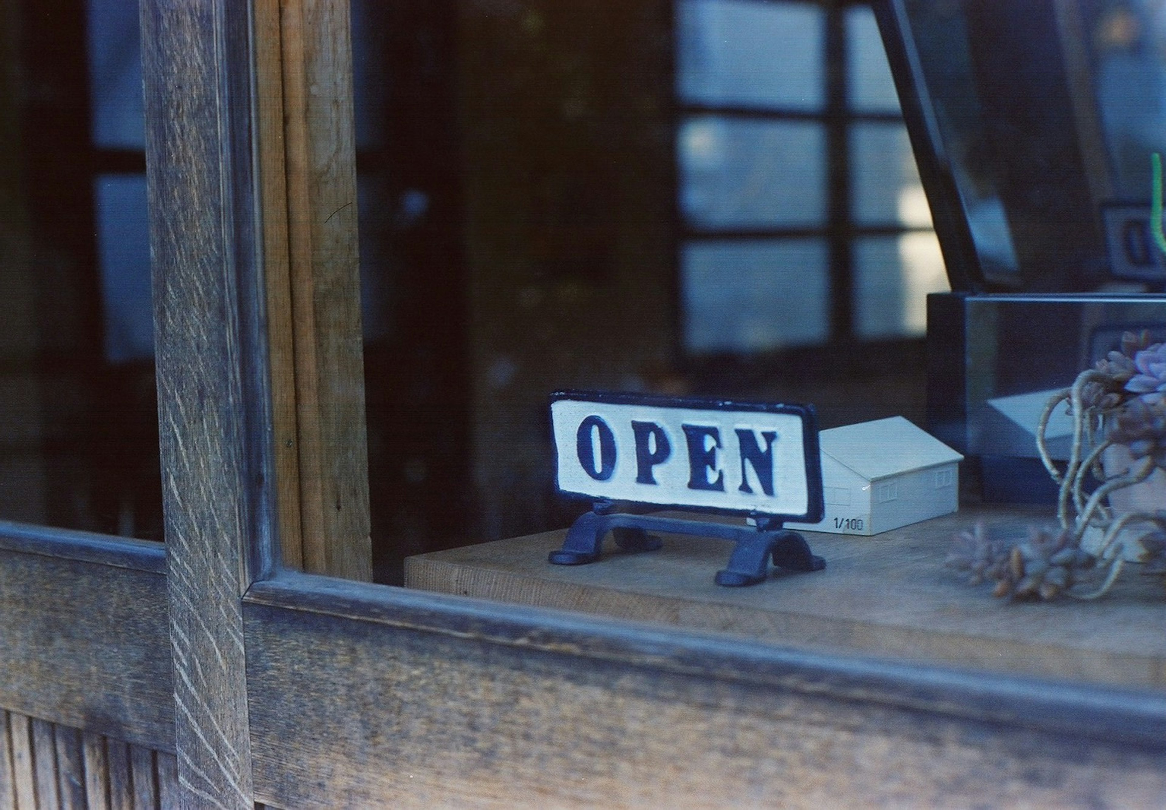 Una tienda de madera con un cartel 'OPEN' cerca de la ventana