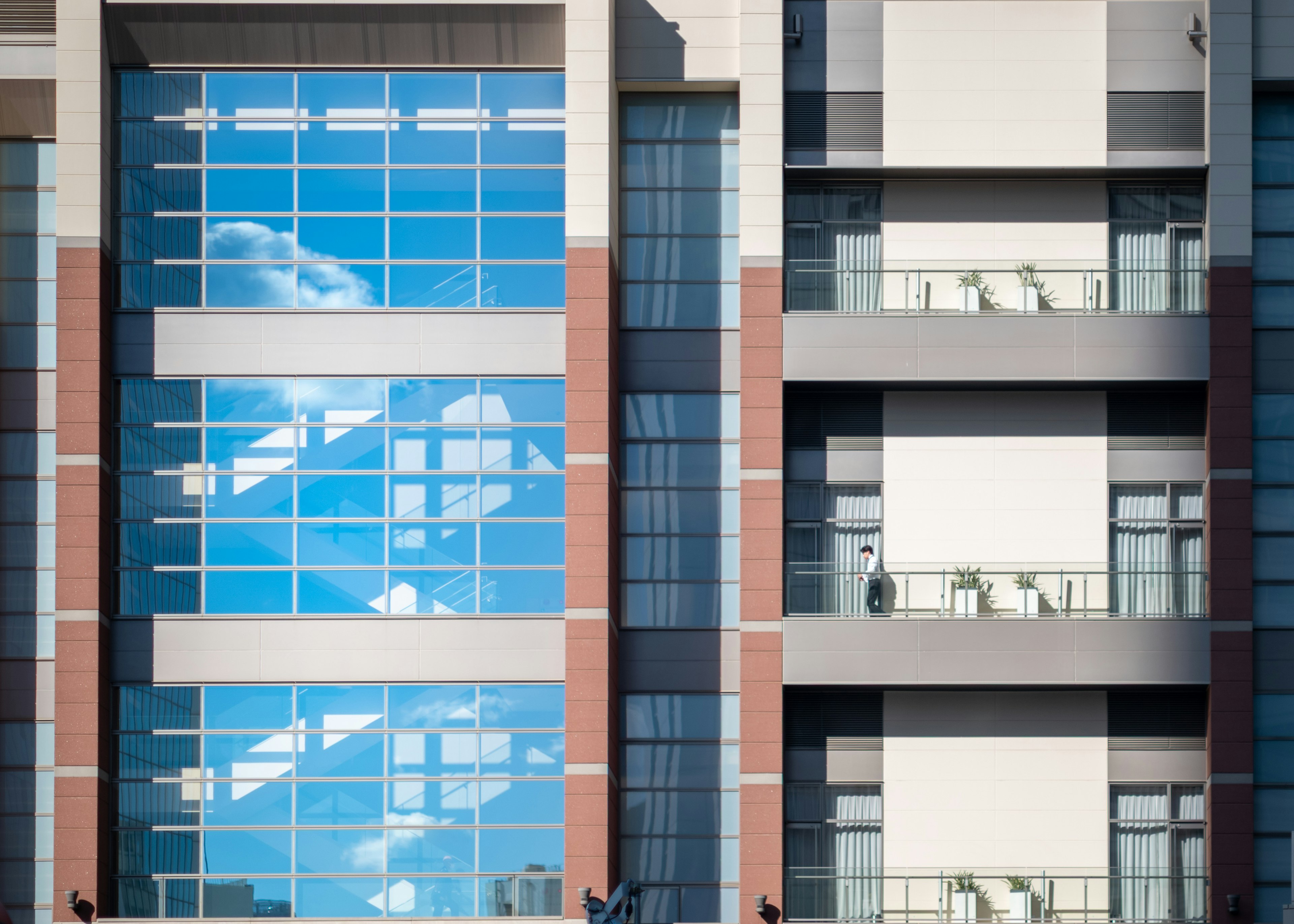 Moderne Gebäude mit reflektierenden Fenstern, die den Himmel zeigen