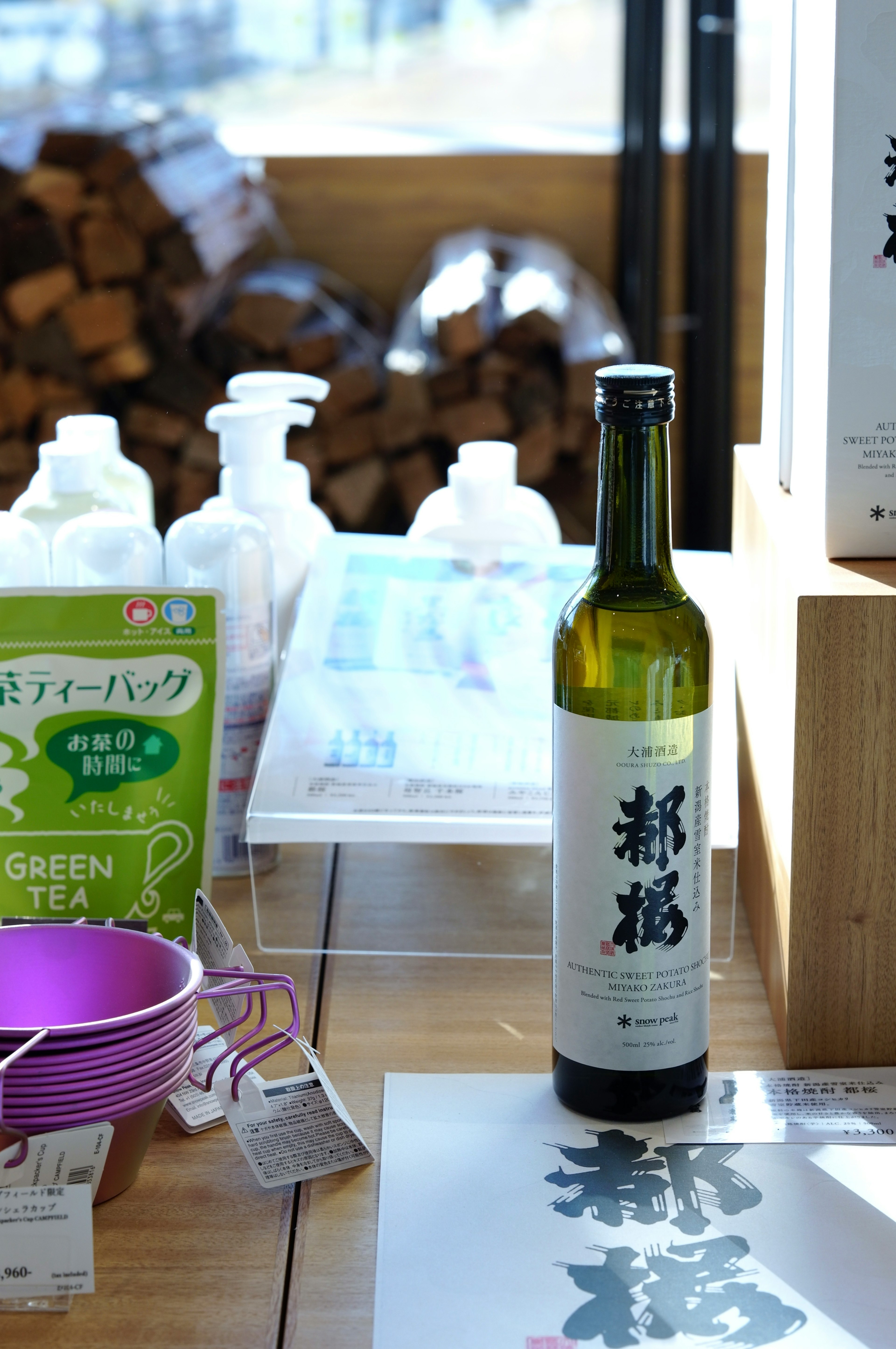 Bouteille de thé vert et sachets de thé sur une table en bois