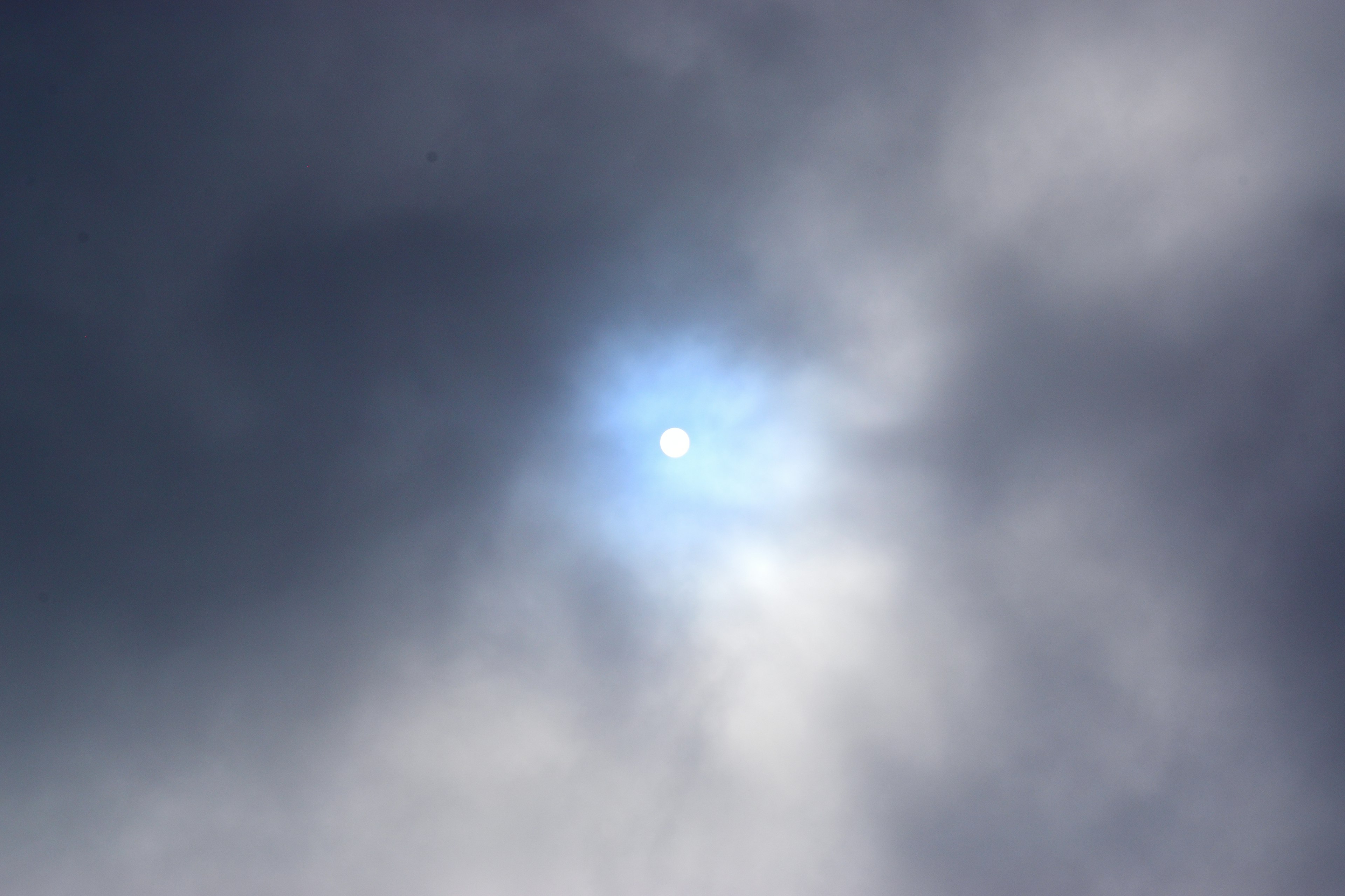 Soleil visible à travers les nuages avec une lueur bleue