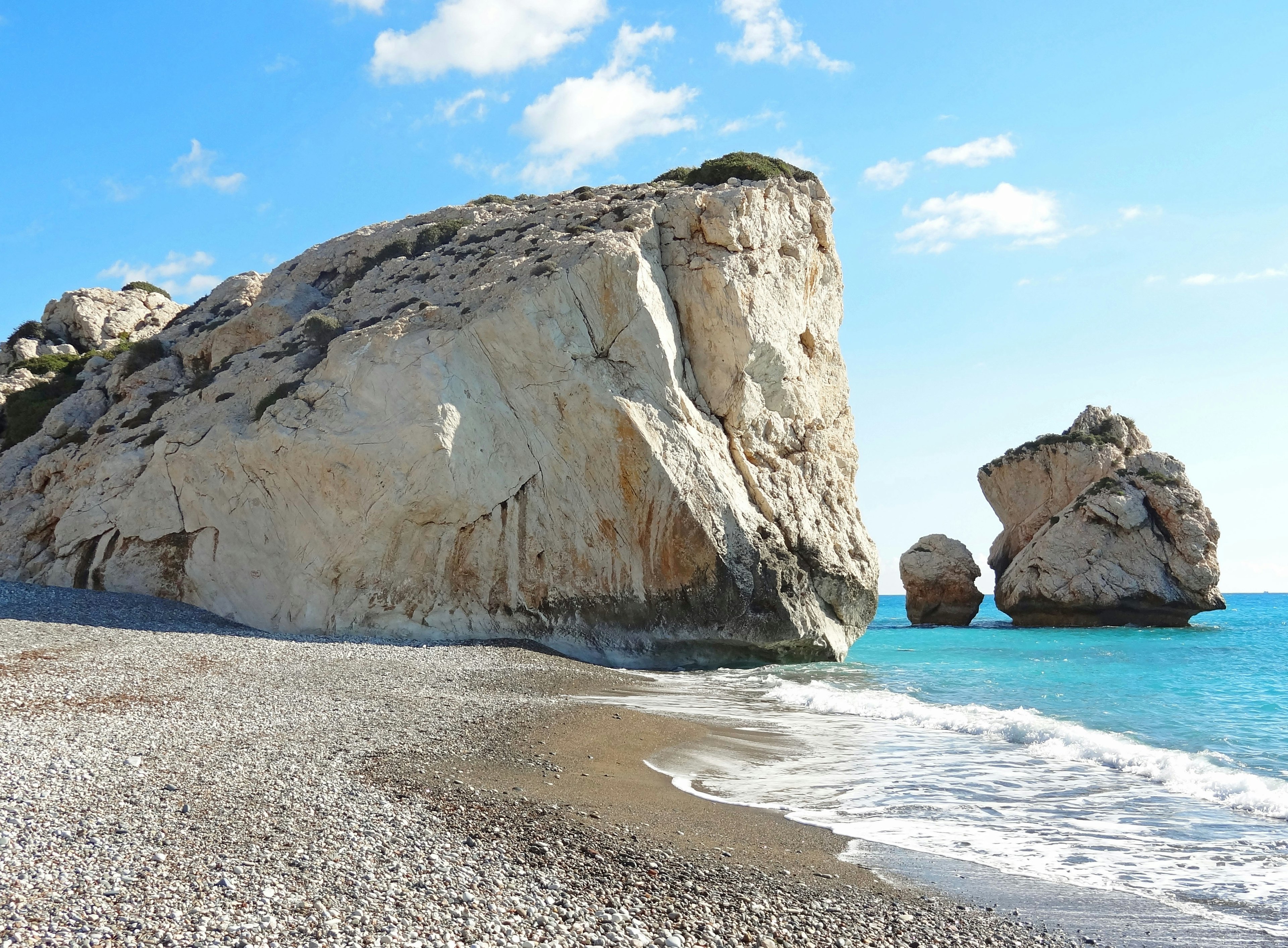 Beach scene featuring blue sea and white rocks