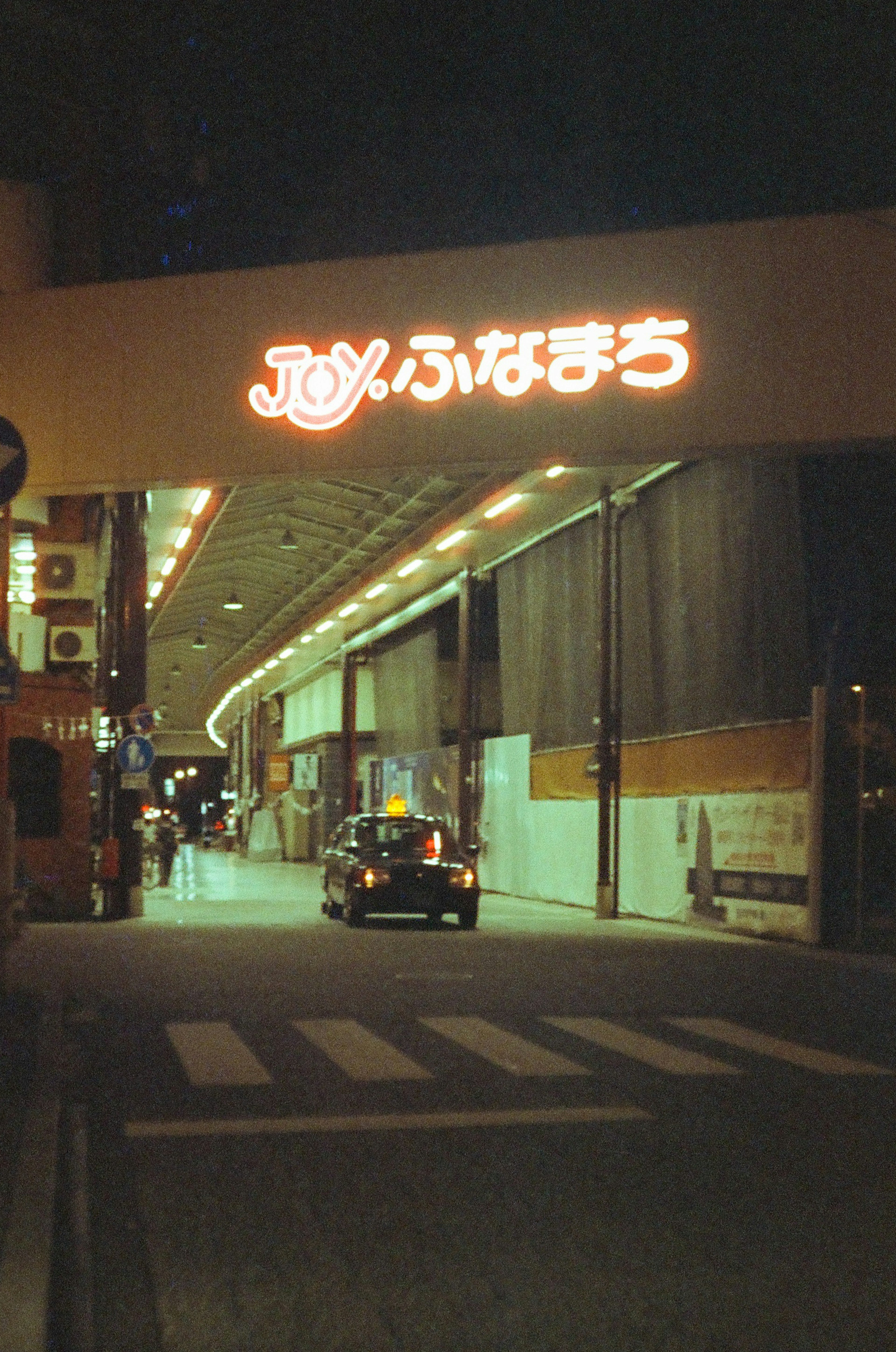 夜の街並みにあるJOYふなまちの看板と通り