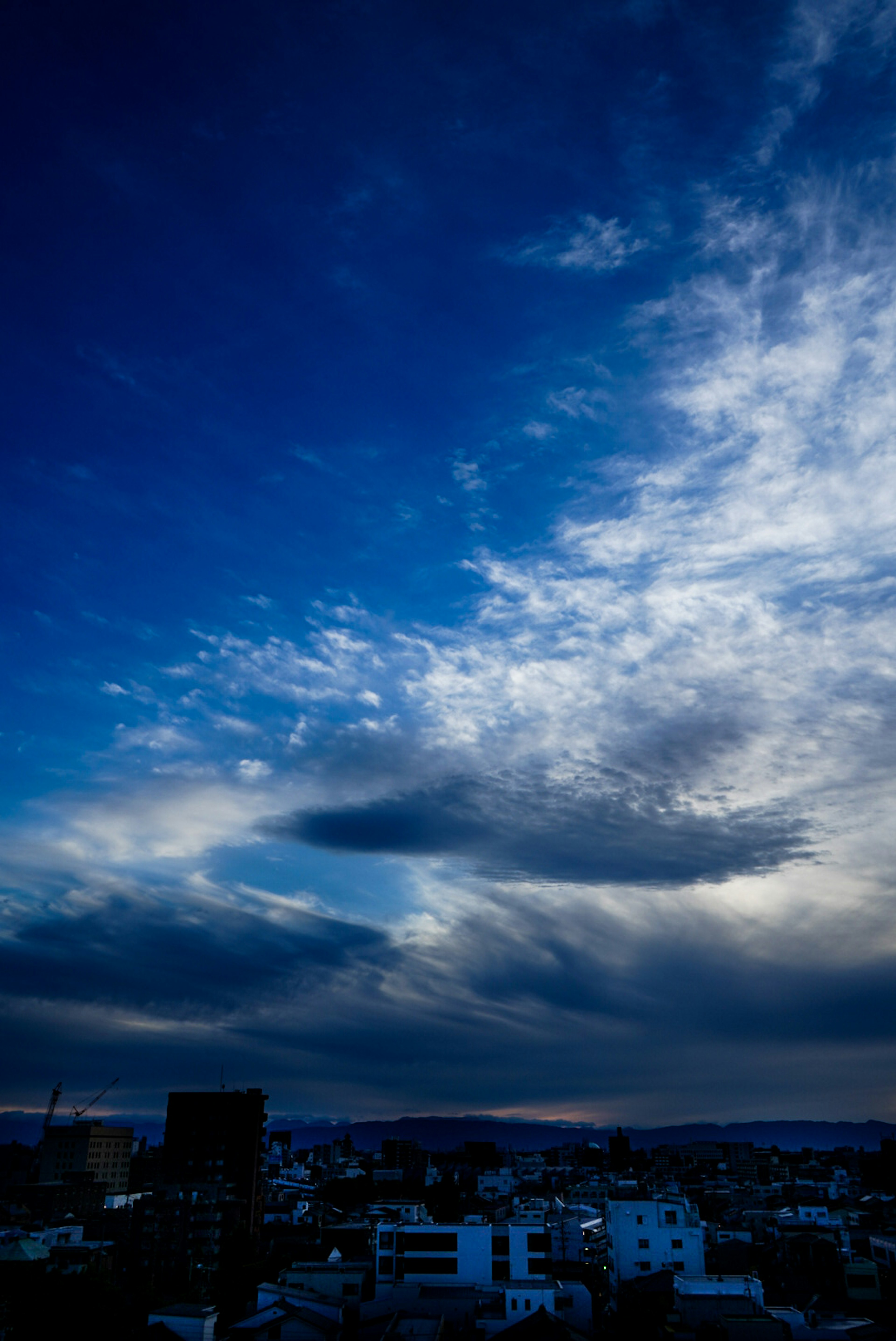 青い空に白い雲が広がる都市の風景