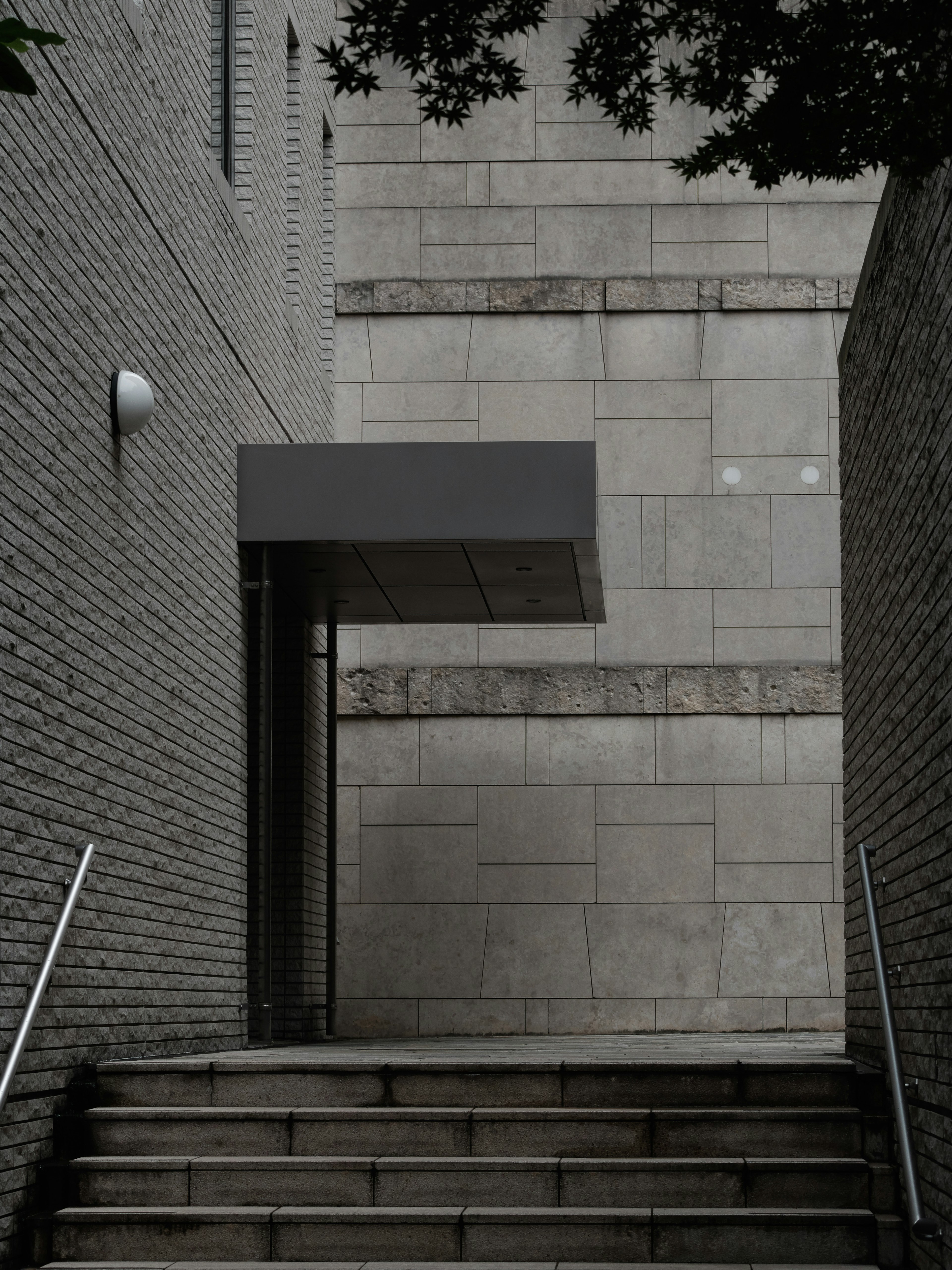 Entrada de edificio moderno en la cima de una escalera Paredes de azulejos grises crean un aspecto minimalista