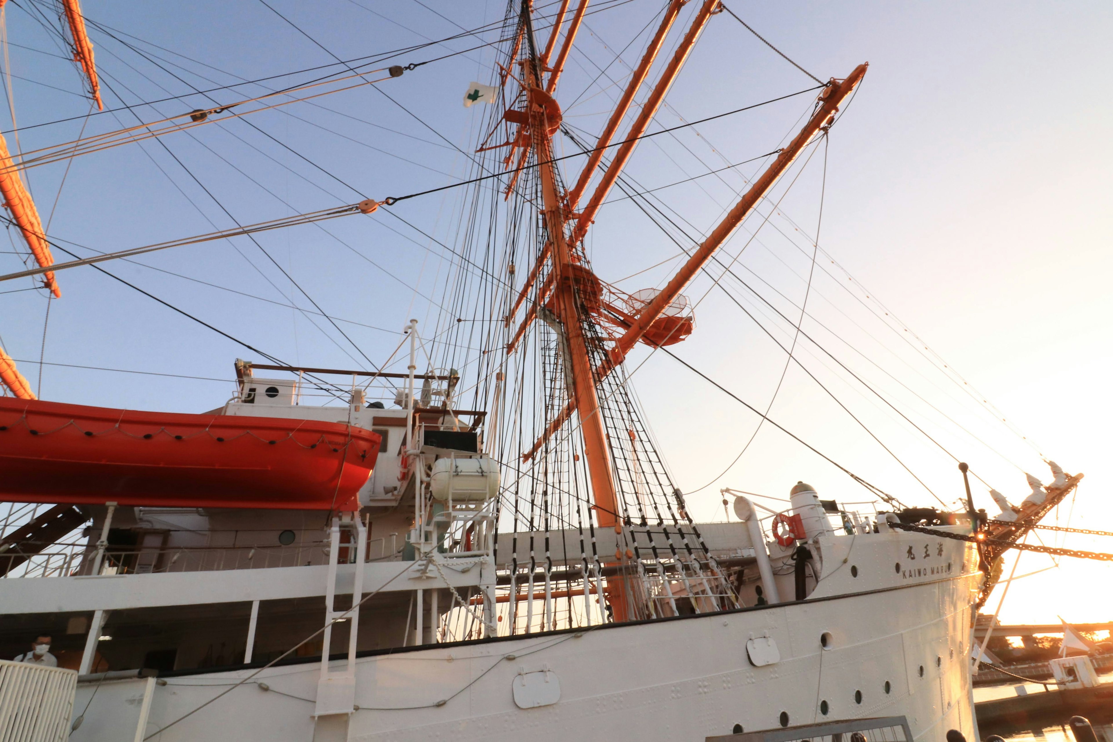 Großes Schiff mit Masten und sichtbarem orangefarbenen Rettungsboot