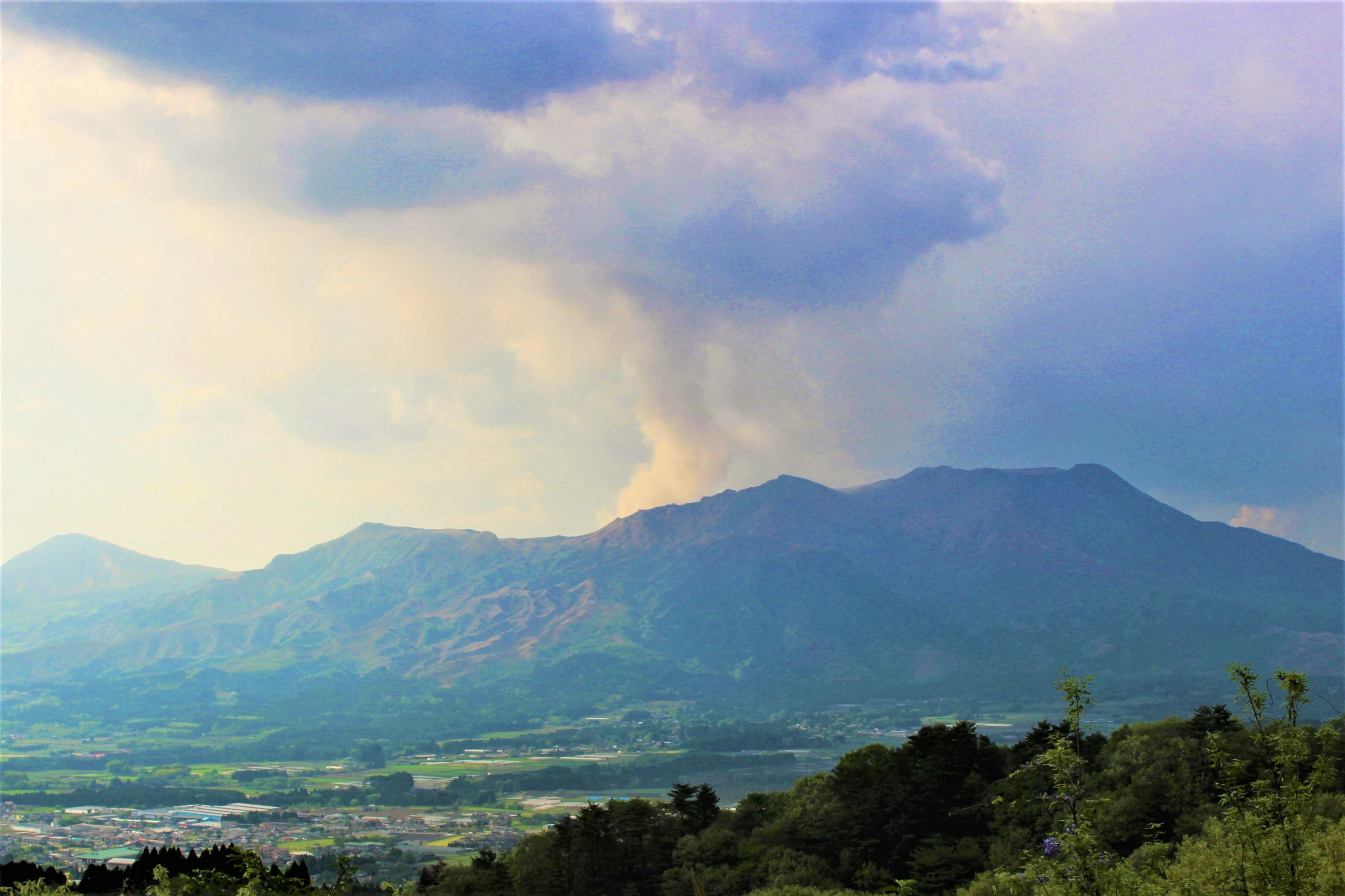 Landscape with smoke rising between mountains