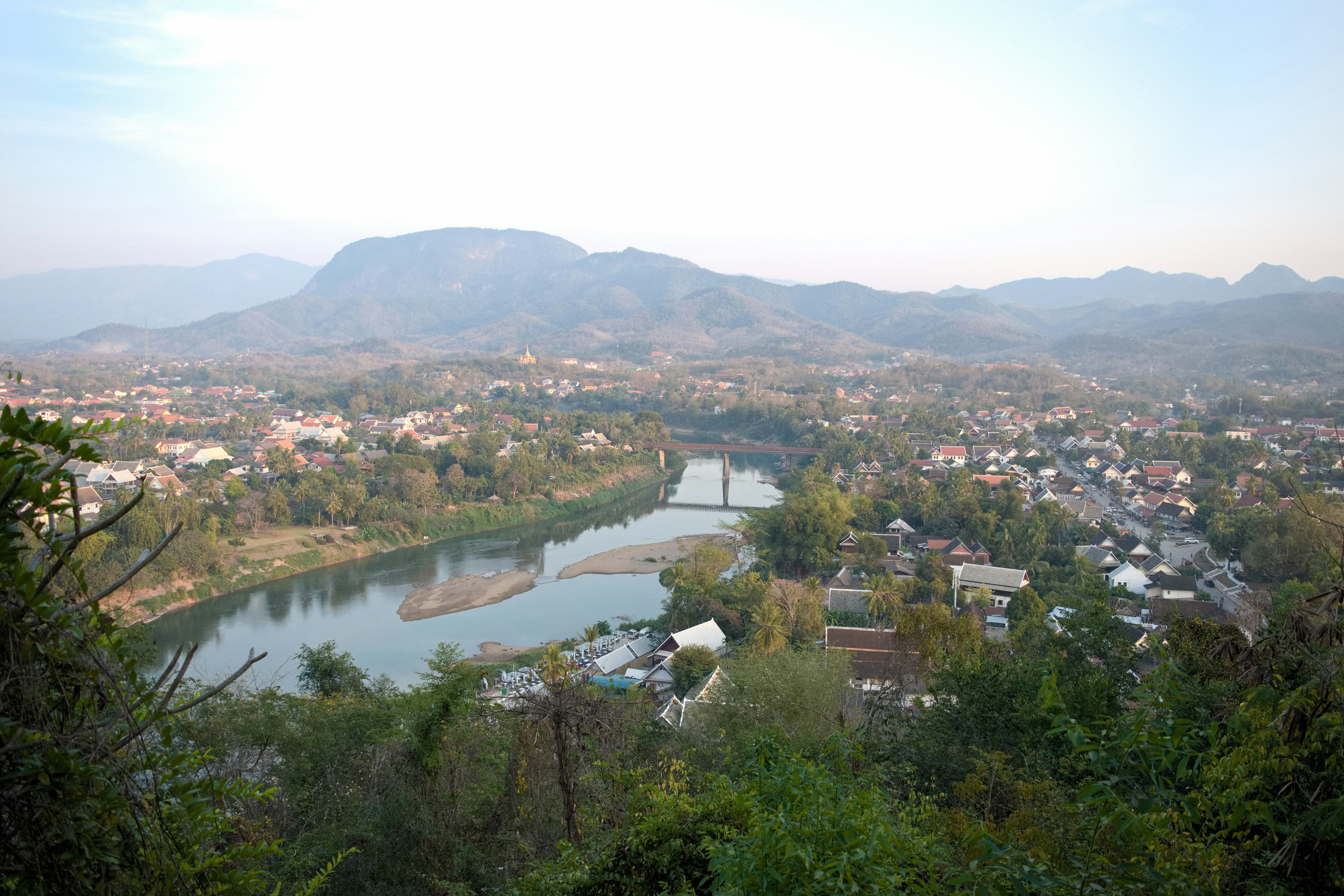 Pemandangan panorama sungai dan kota dikelilingi pegunungan