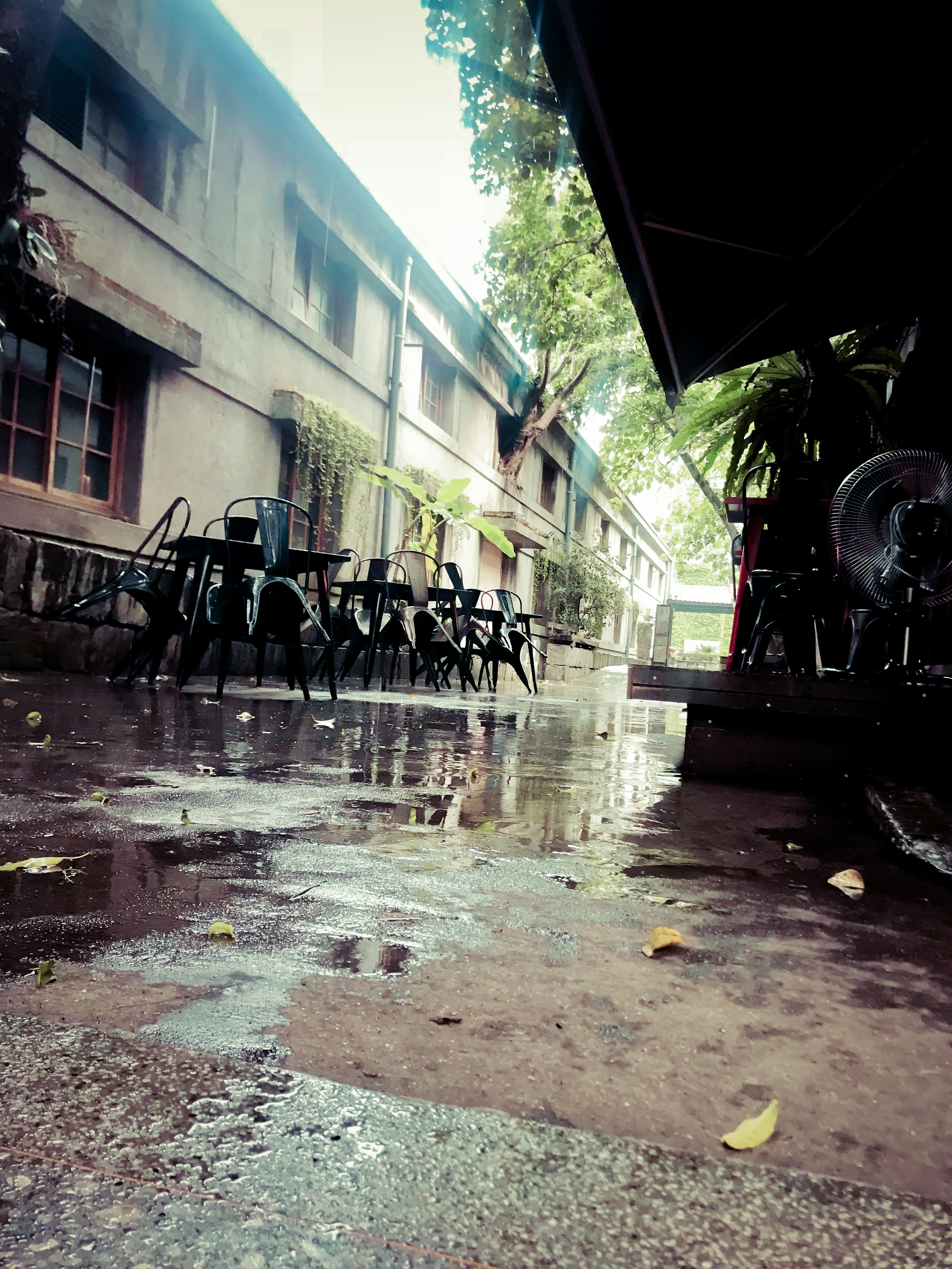 Patio tranquilo después de la lluvia con sillas y charcos