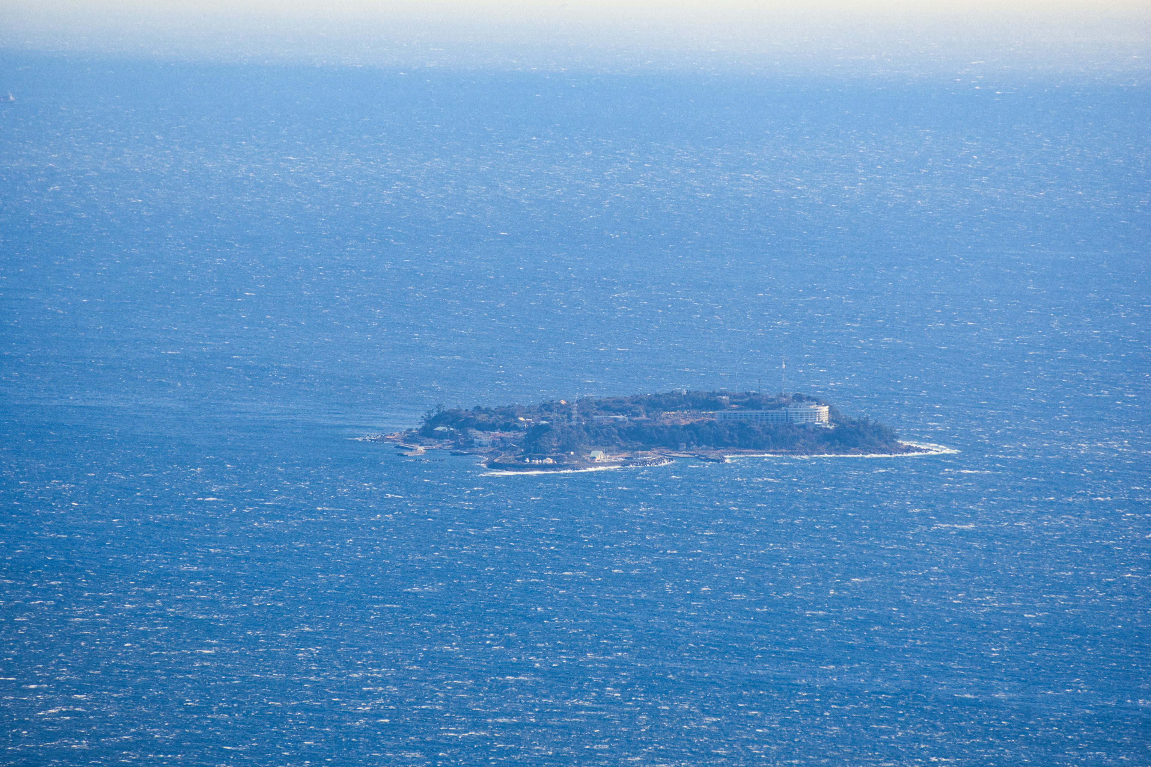 Vue aérienne d'une île flottant sur des eaux bleues