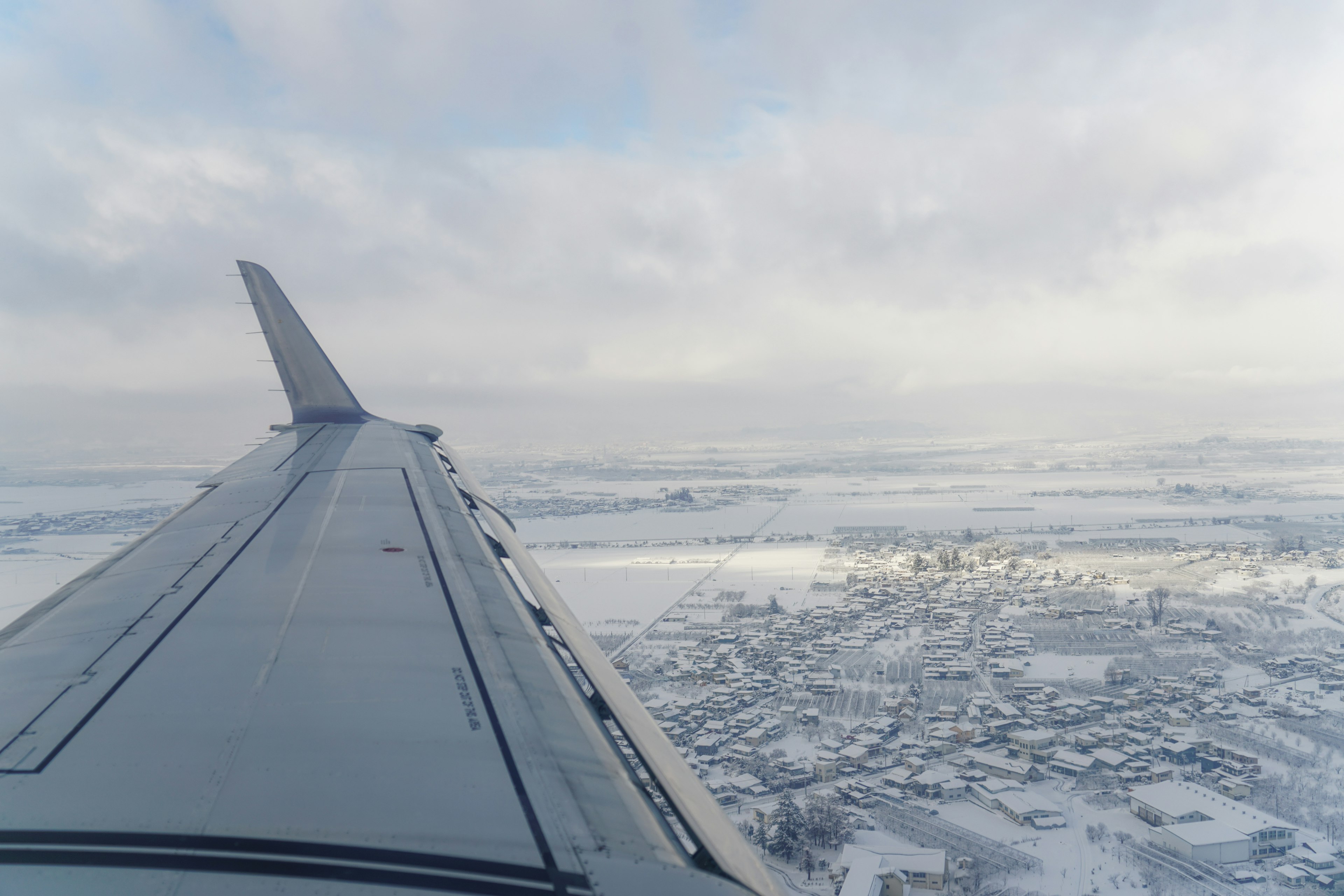 View from an airplane wing over a snowy landscape