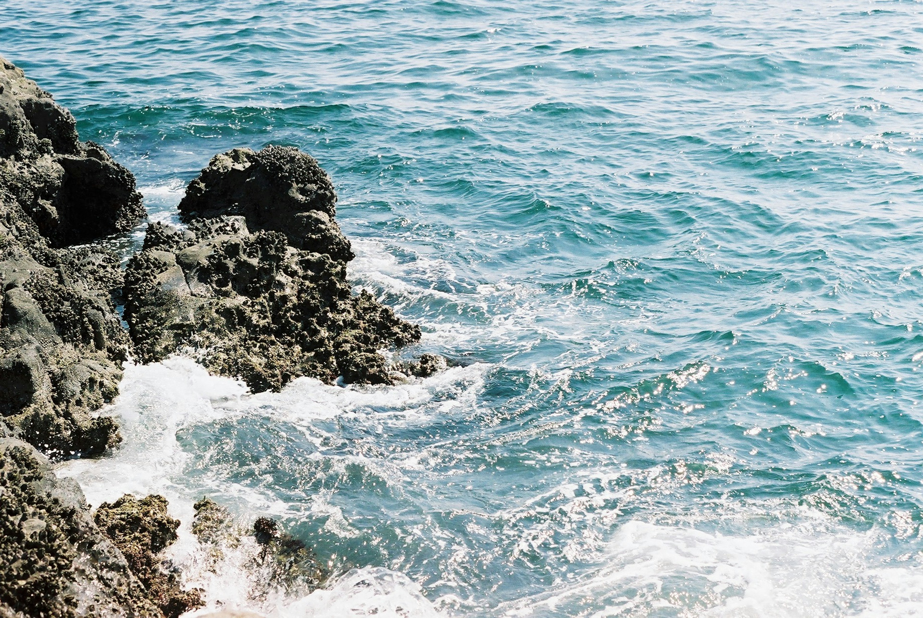 Blue ocean and rocky landscape waves crashing against the rocks