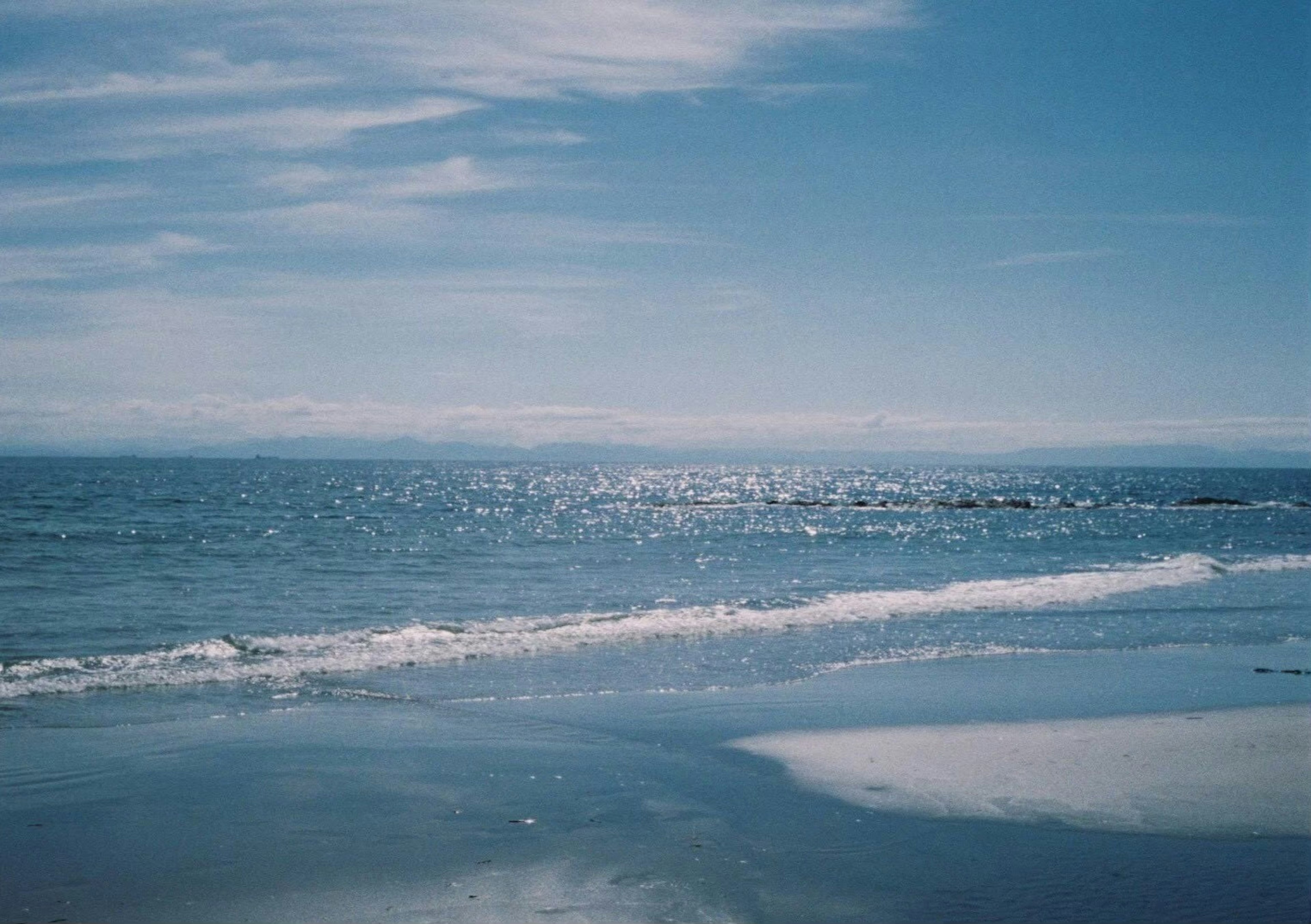 Vue pittoresque de l'océan bleu et du ciel vagues douces s'échouant sur le rivage