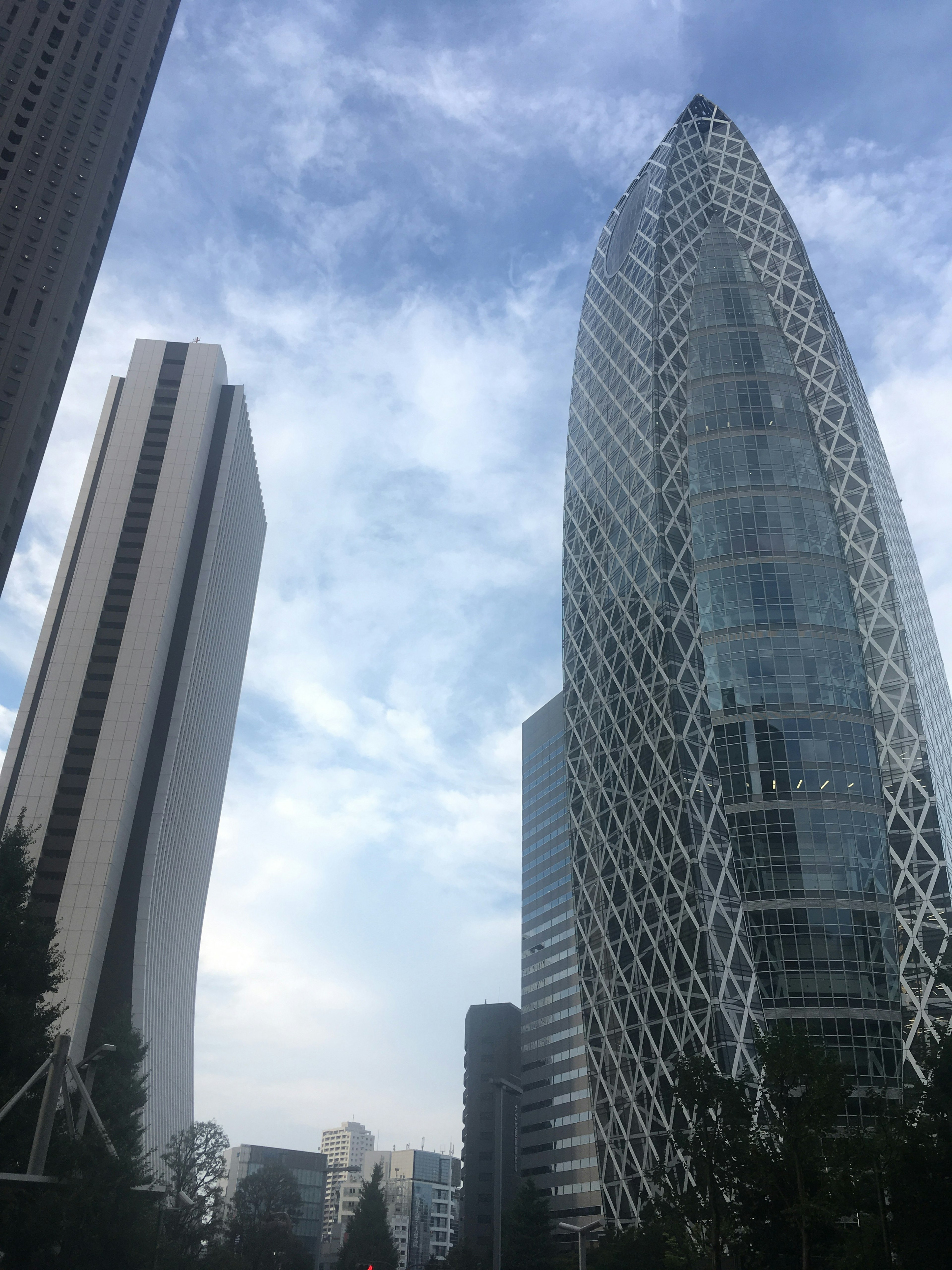 Pemandangan kota dengan gedung pencakar langit modern dan desain arsitektur unik di bawah langit biru