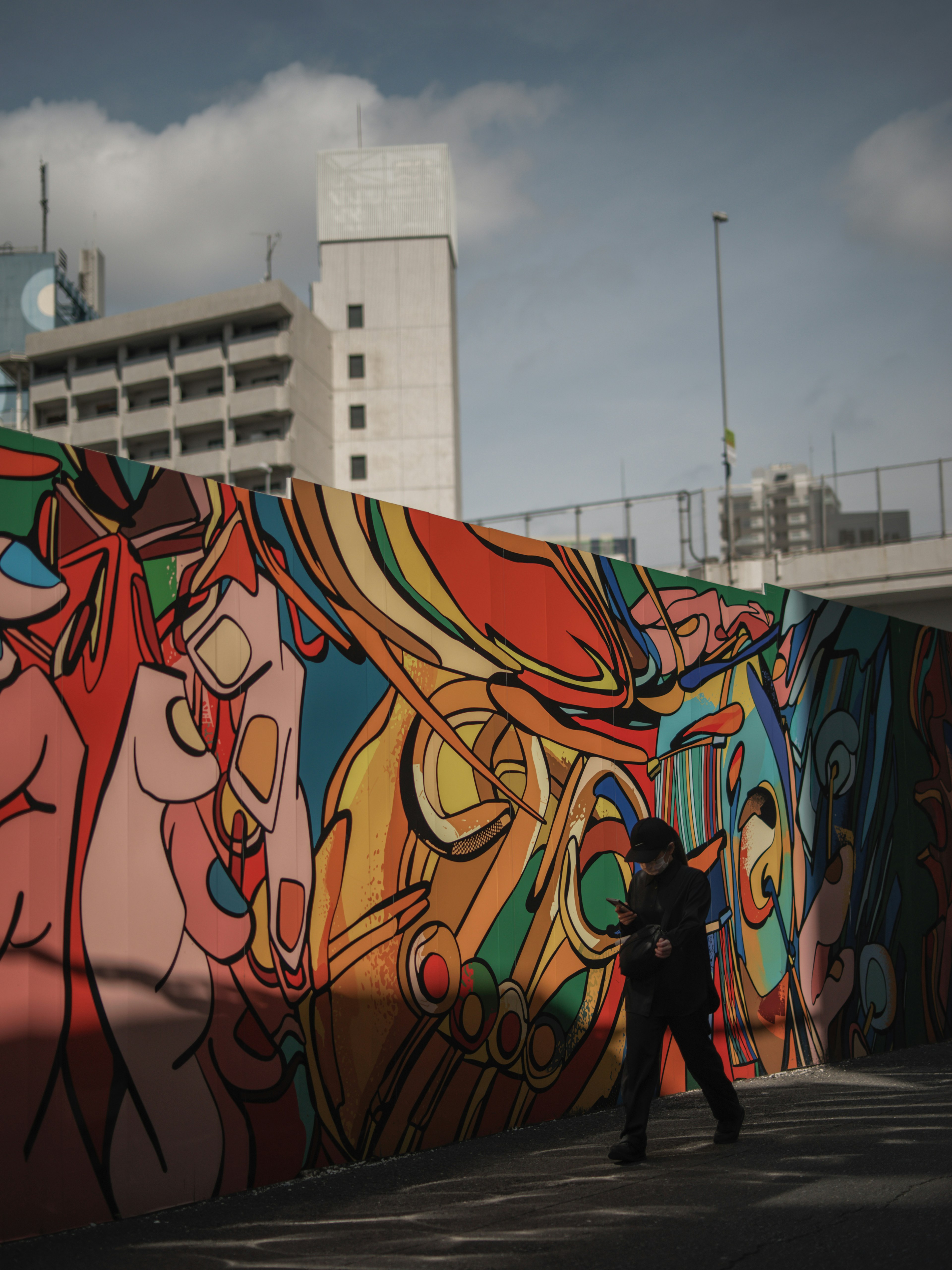 Persona che cammina davanti a un murale colorato scena urbana