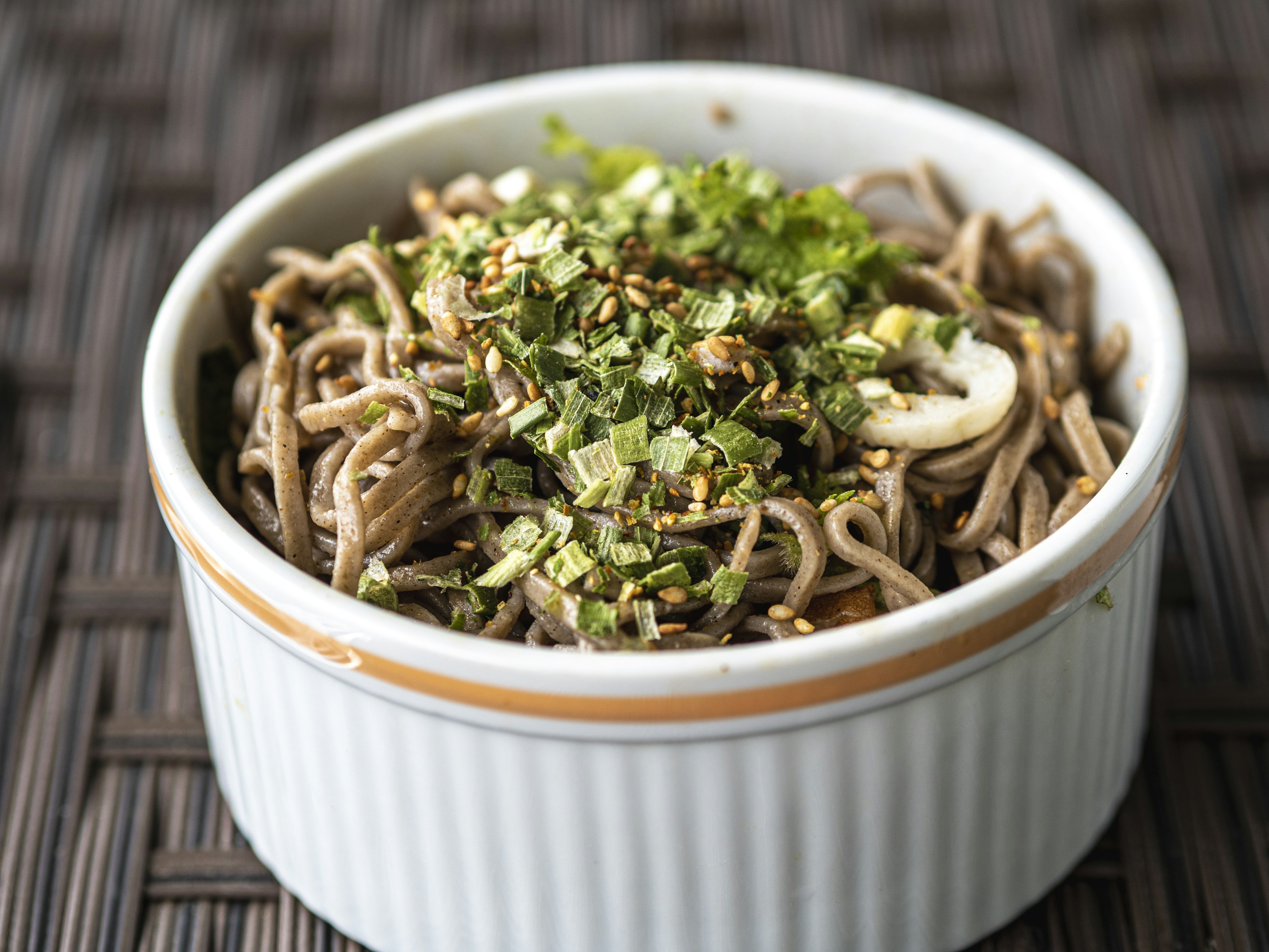 Ciotola di noodles soba con cipollotti tritati e semi di sesamo