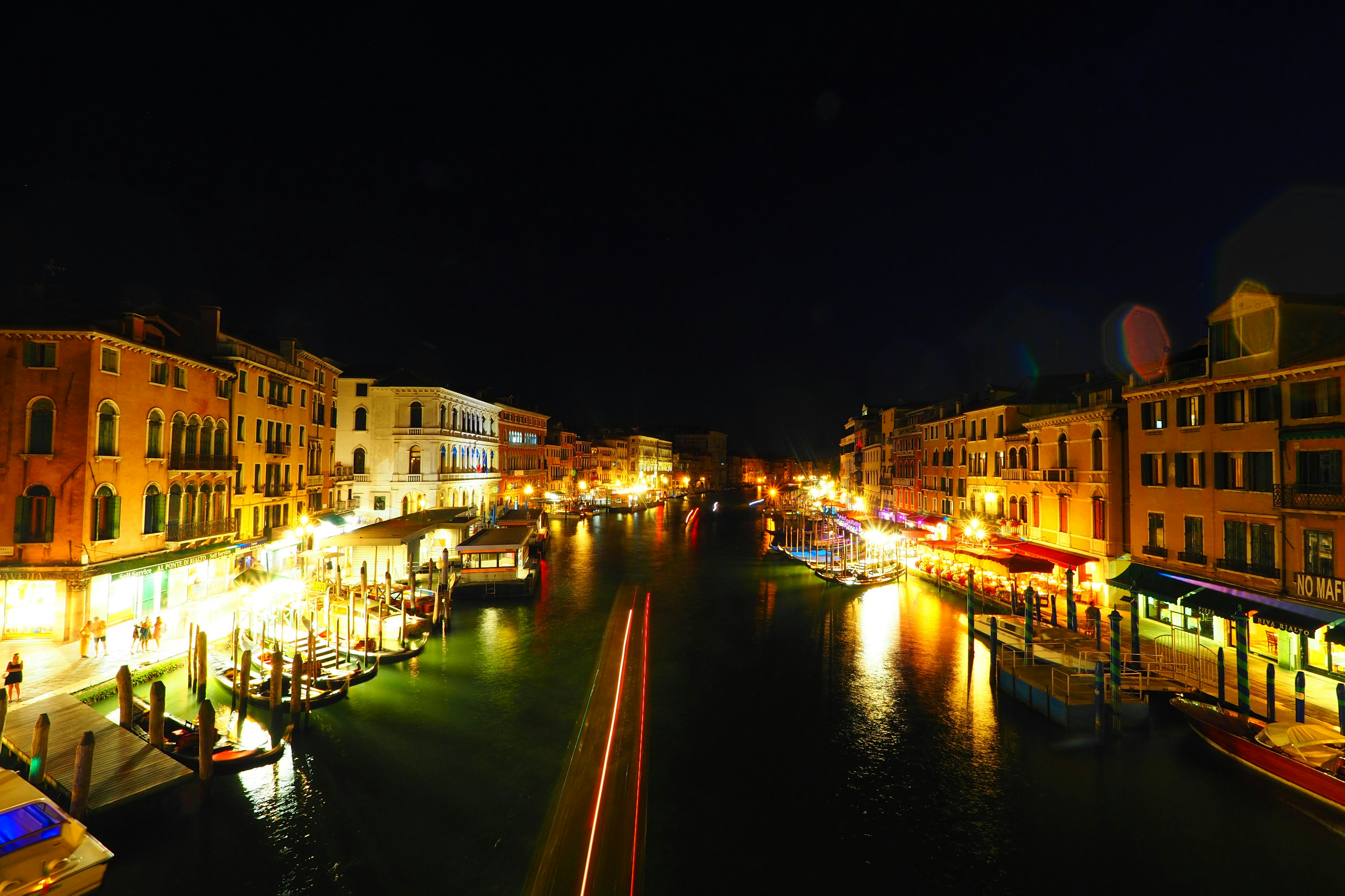 Bella vista di un canale illuminato di notte con edifici