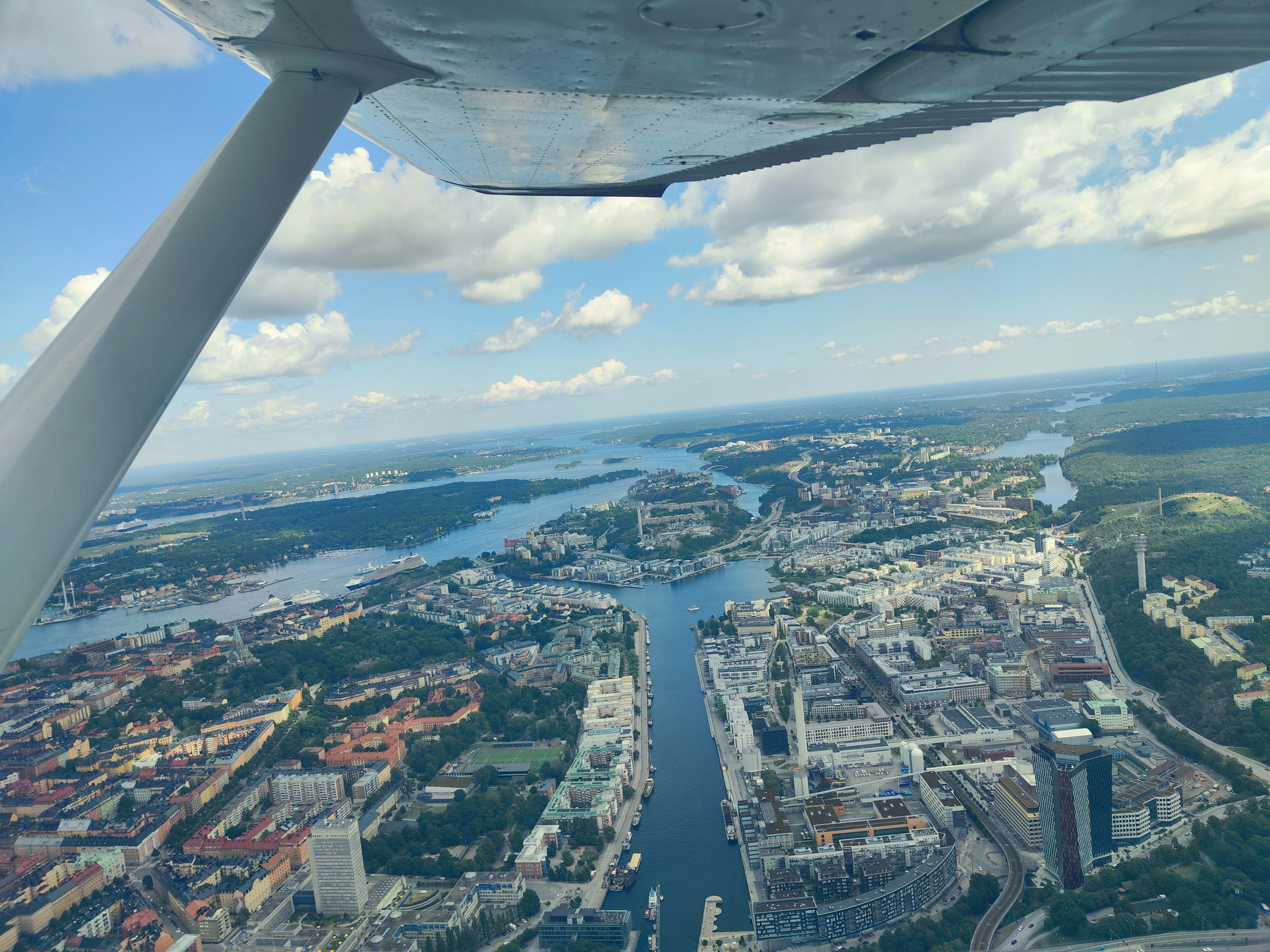 Luftaufnahme einer Stadt und eines Flusses aus einem Flugzeugfenster