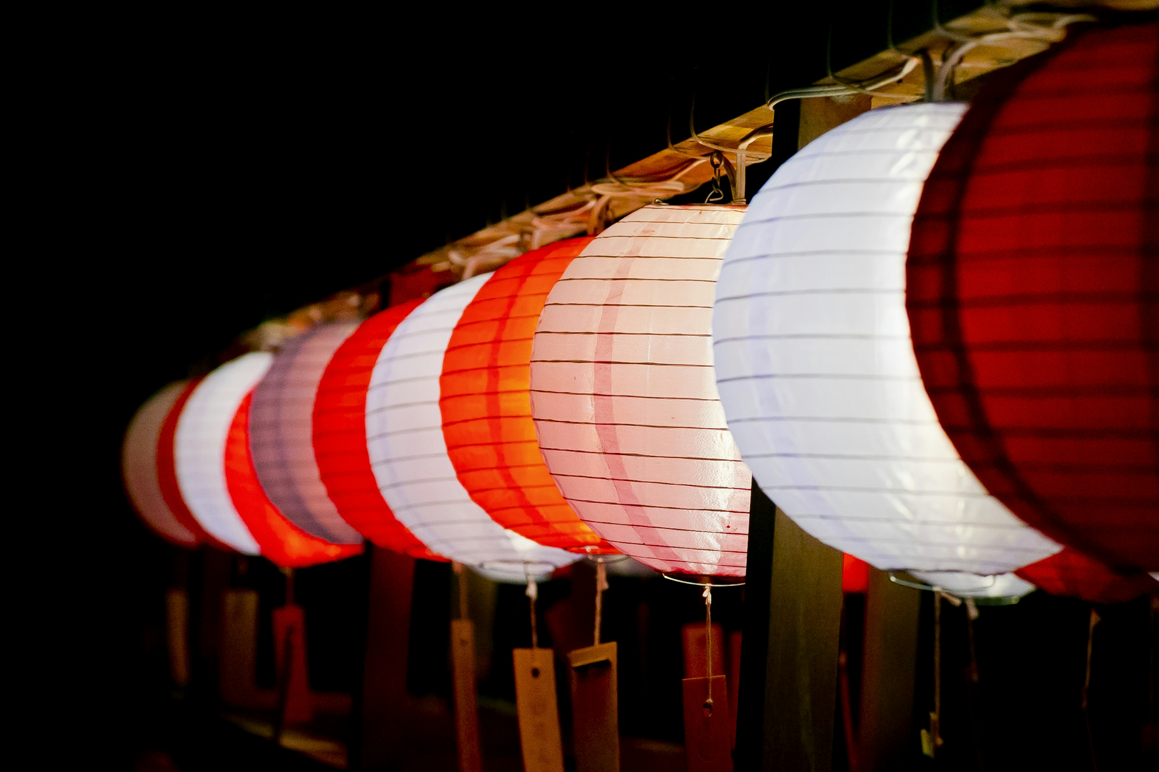 Row of red and white lanterns glowing at night