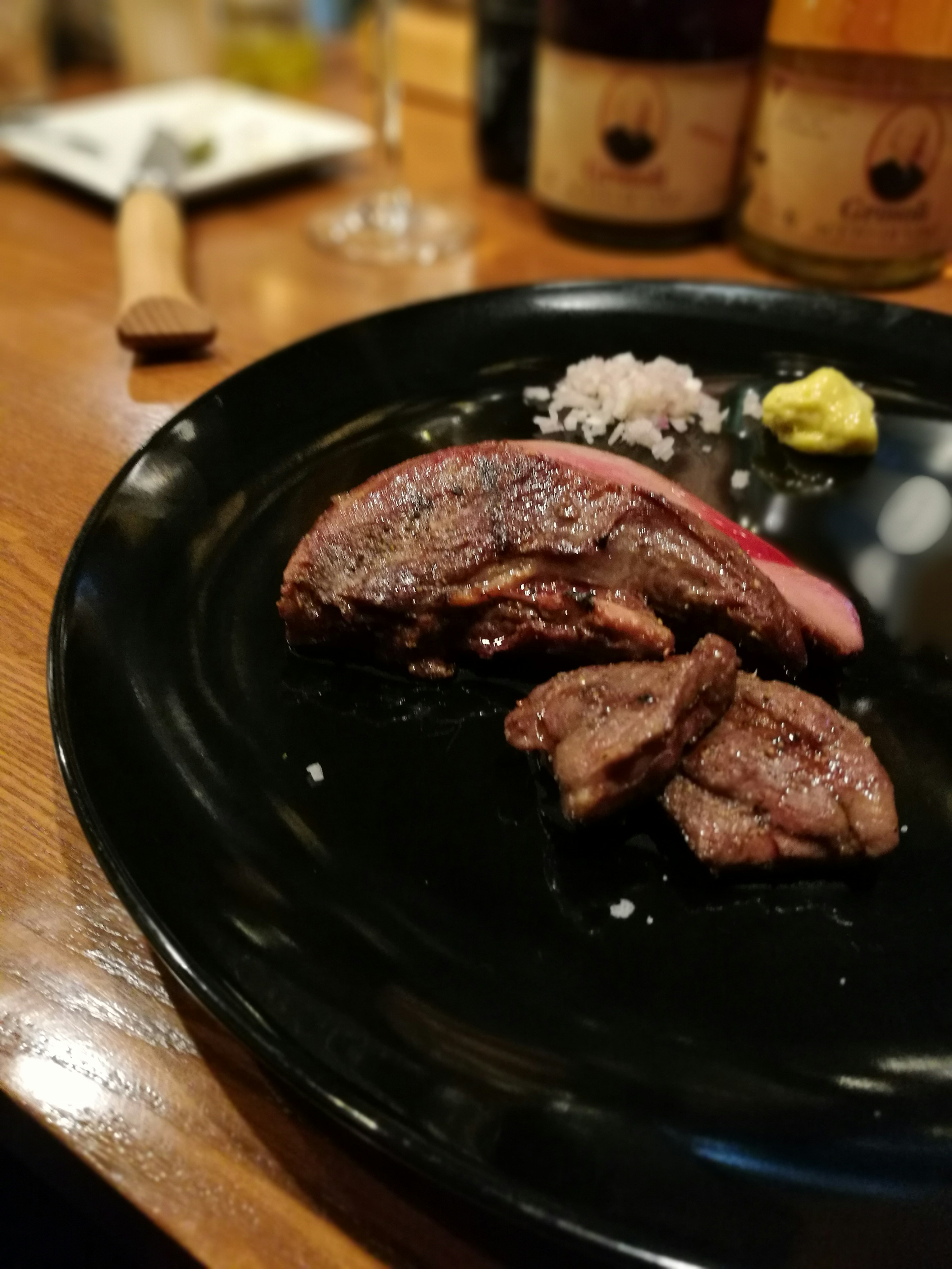 Carne asada servida en un plato negro con condimentos