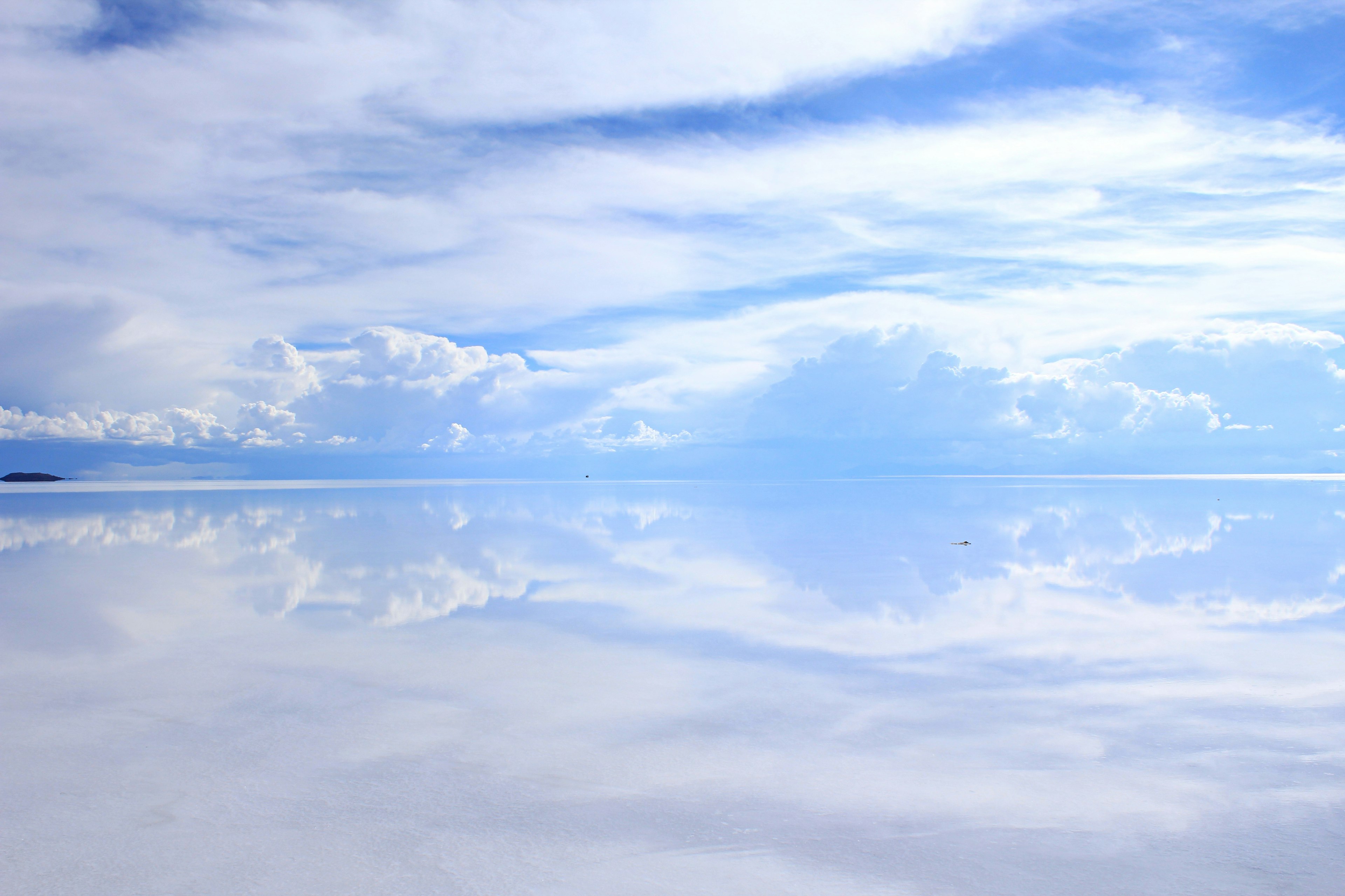 Pemandangan indah dengan langit biru dan awan putih yang memantul di air