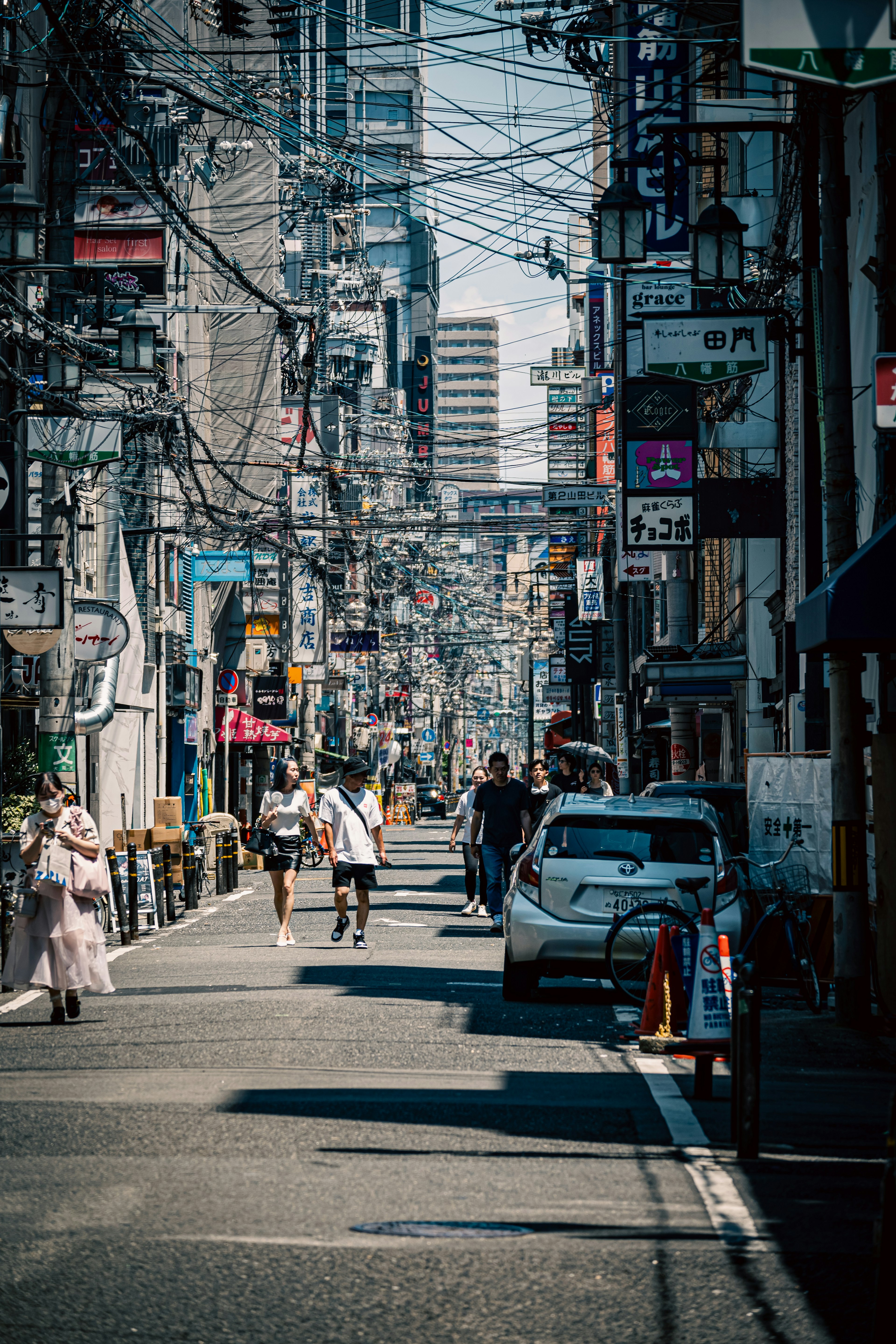 Bustling city street lined with power lines and signage