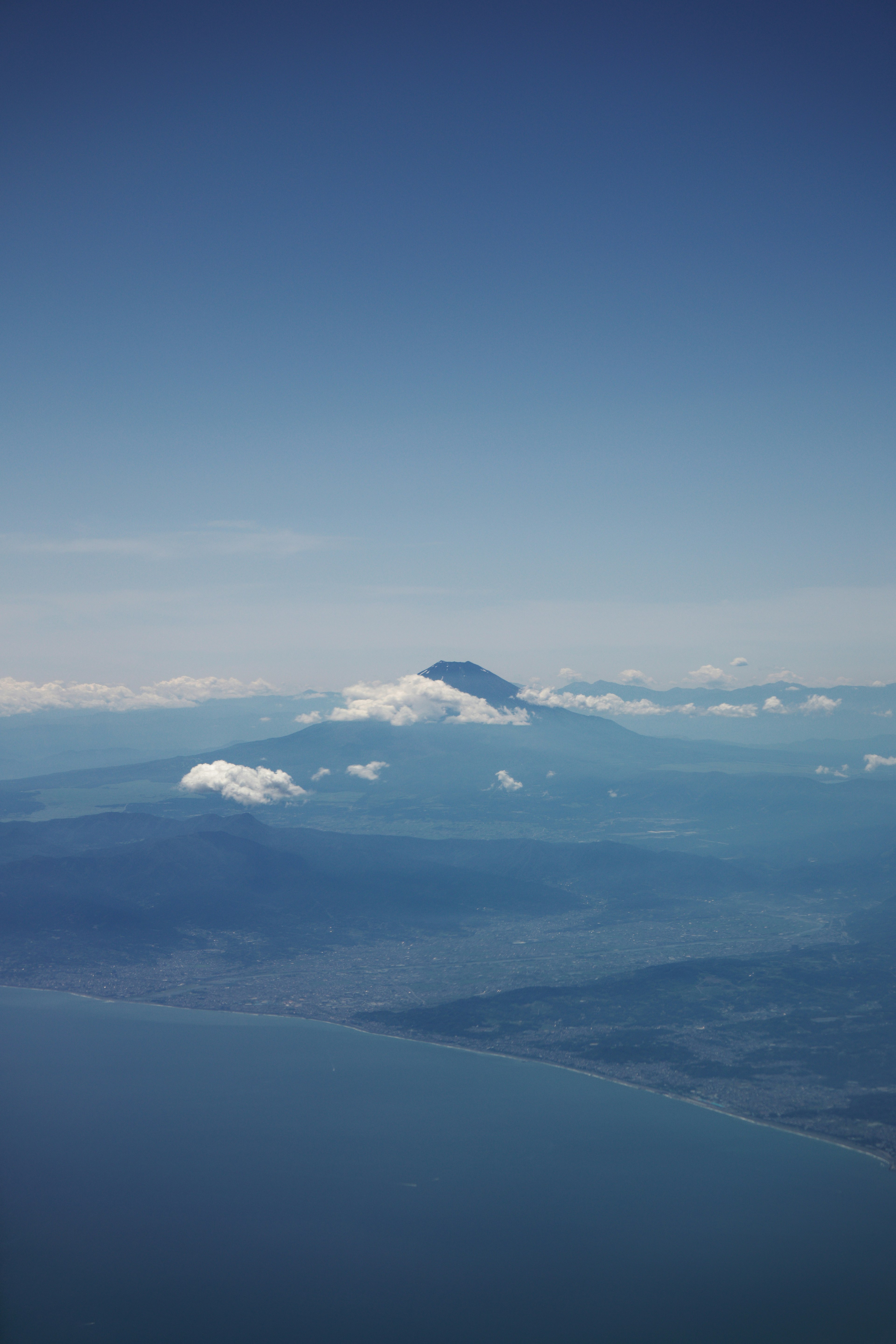 空から見た山と海の風景 雲に覆われた山と青い空