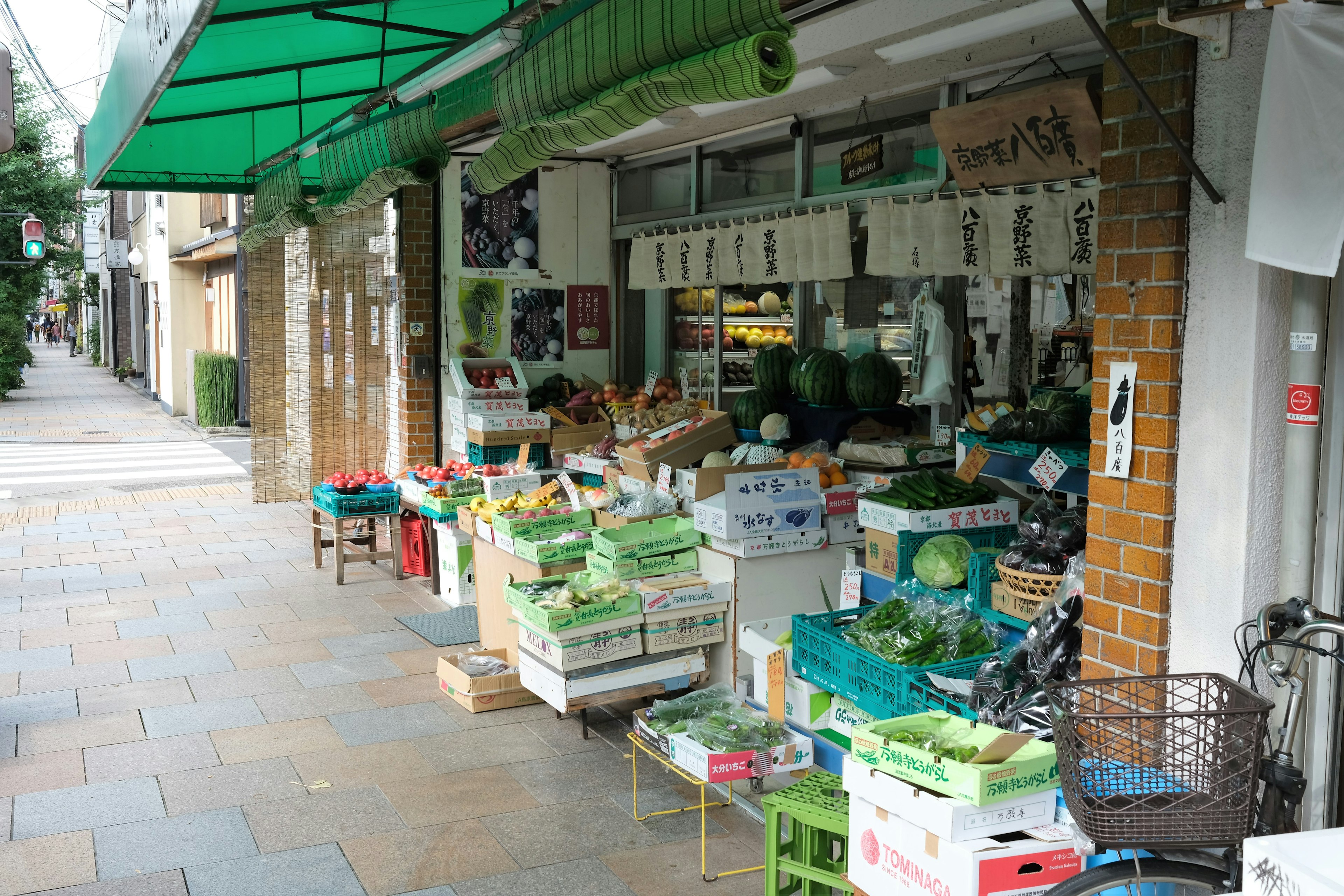 Marché de légumes local sous un auvent vert avec des produits frais exposés à l'extérieur