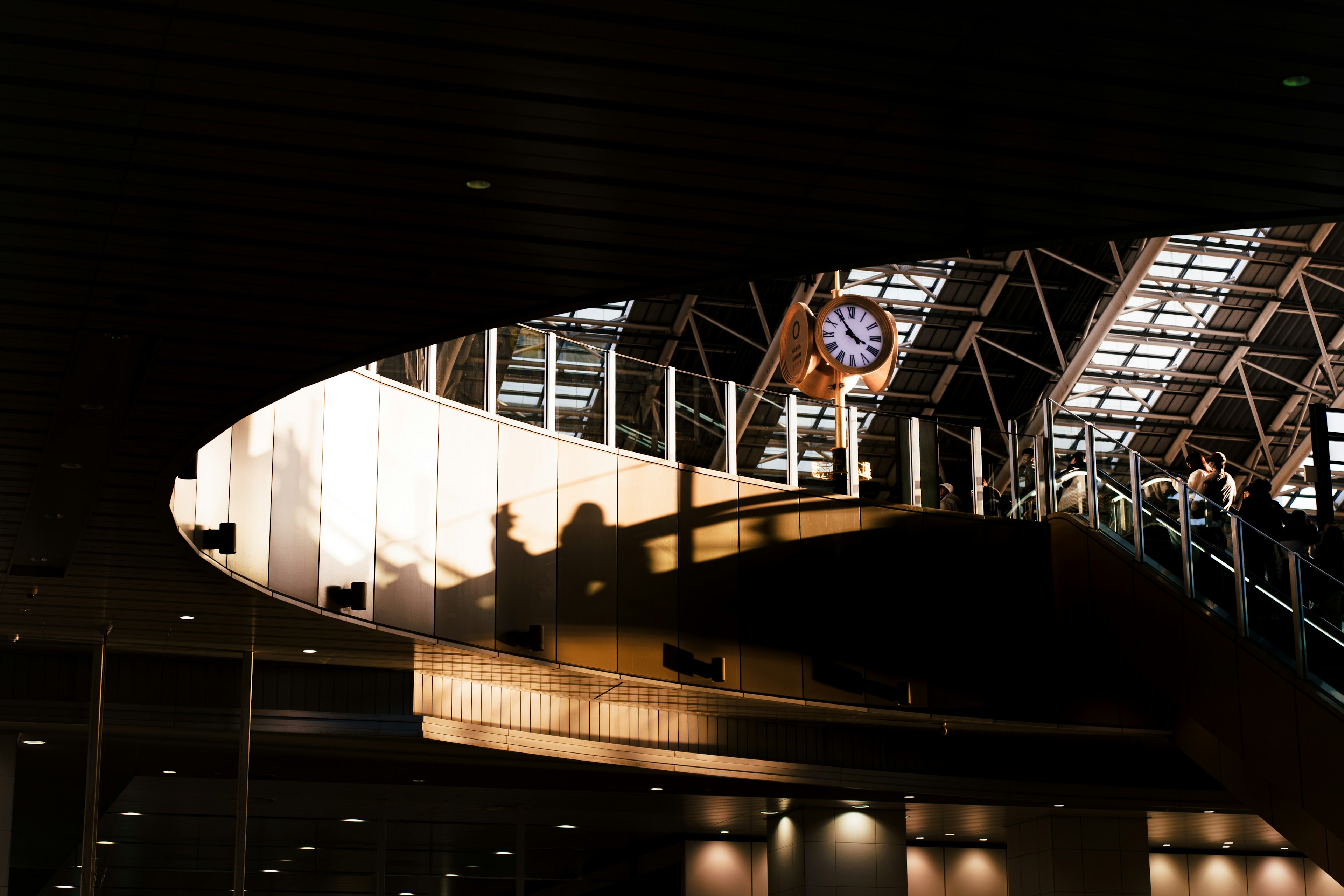 Innenansicht eines Bahnhofs mit sichtbaren Schatten und einer Uhr