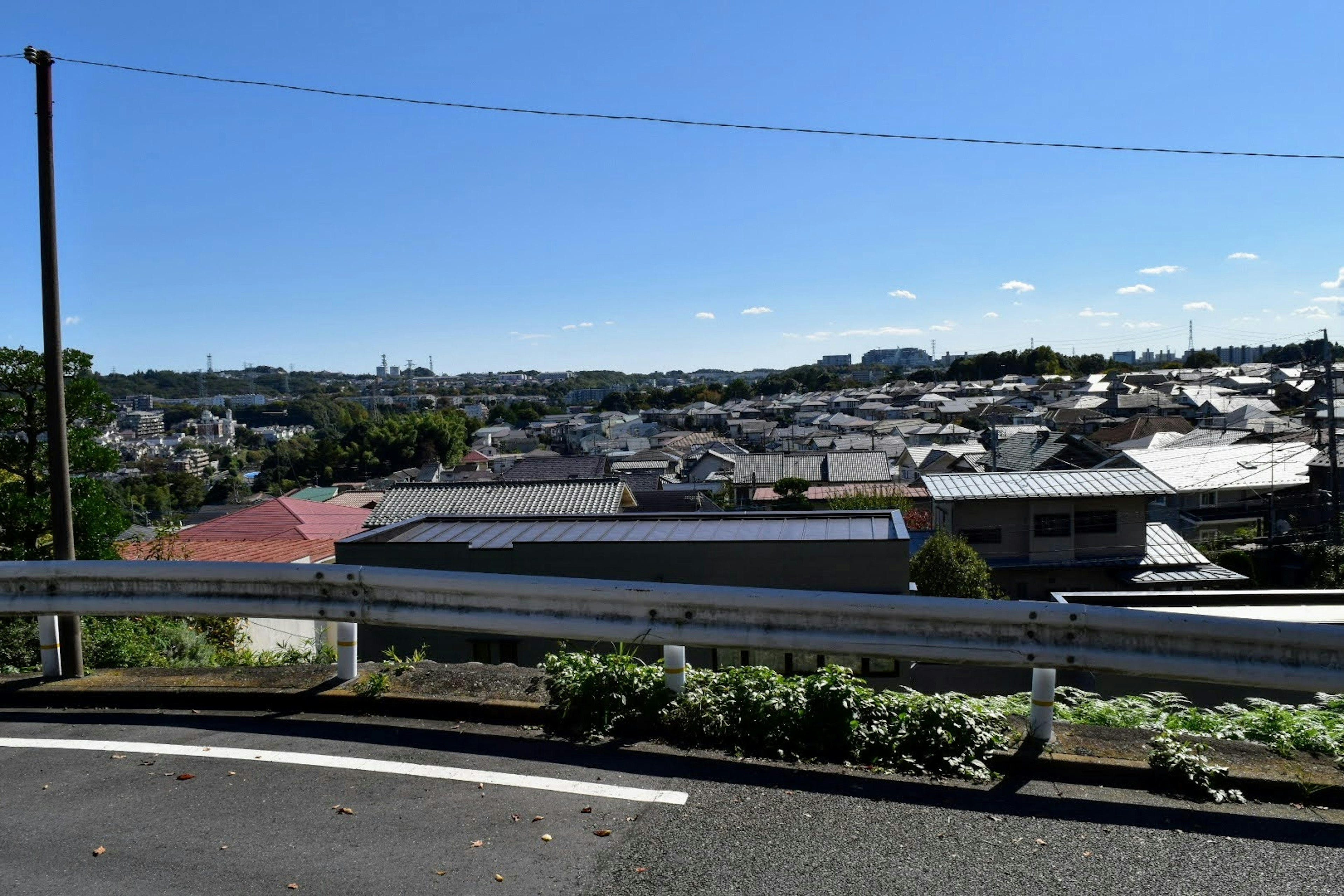 Residential area view under a blue sky with nearby guardrail