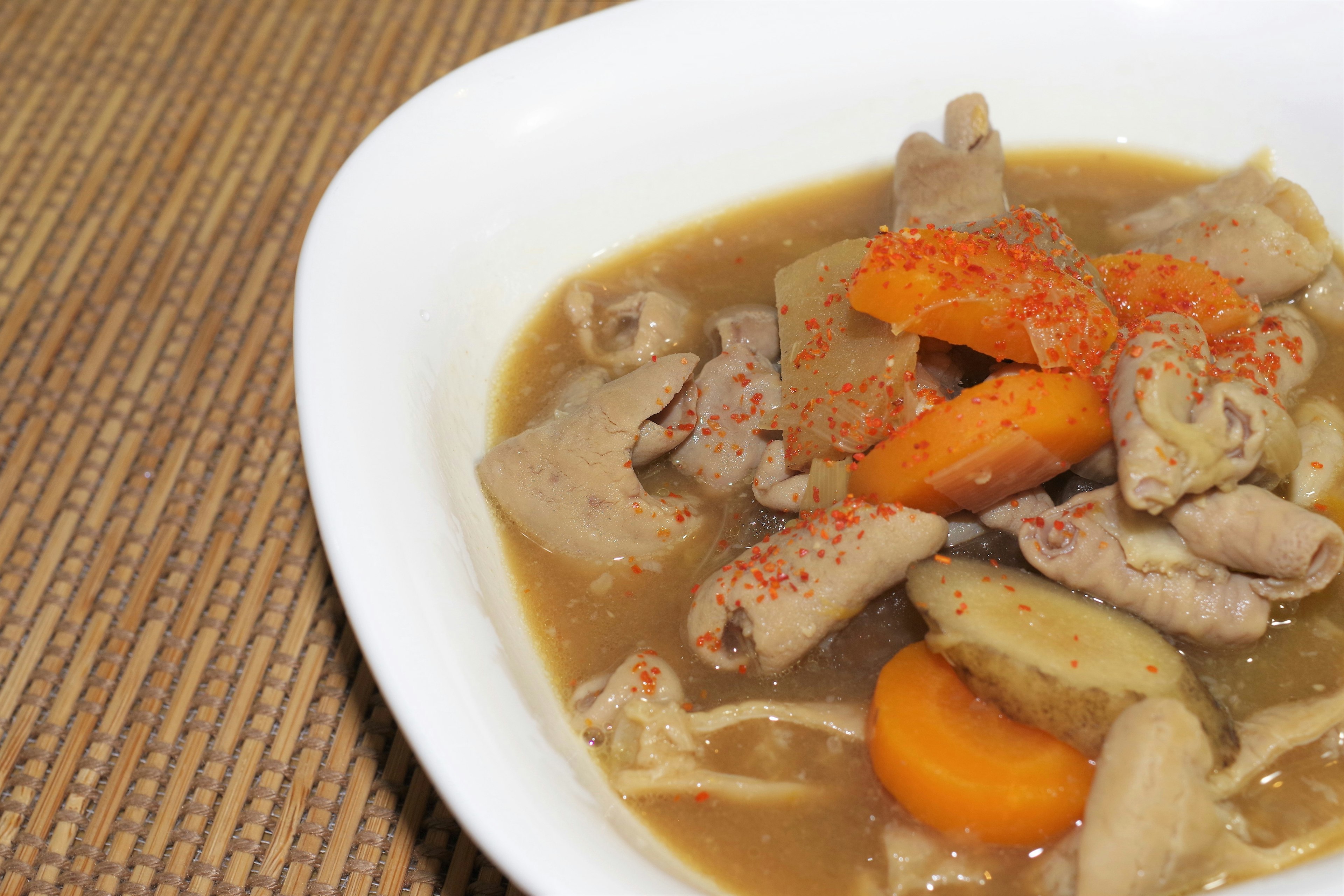 Soupe de poulet et légumes servie dans un bol blanc