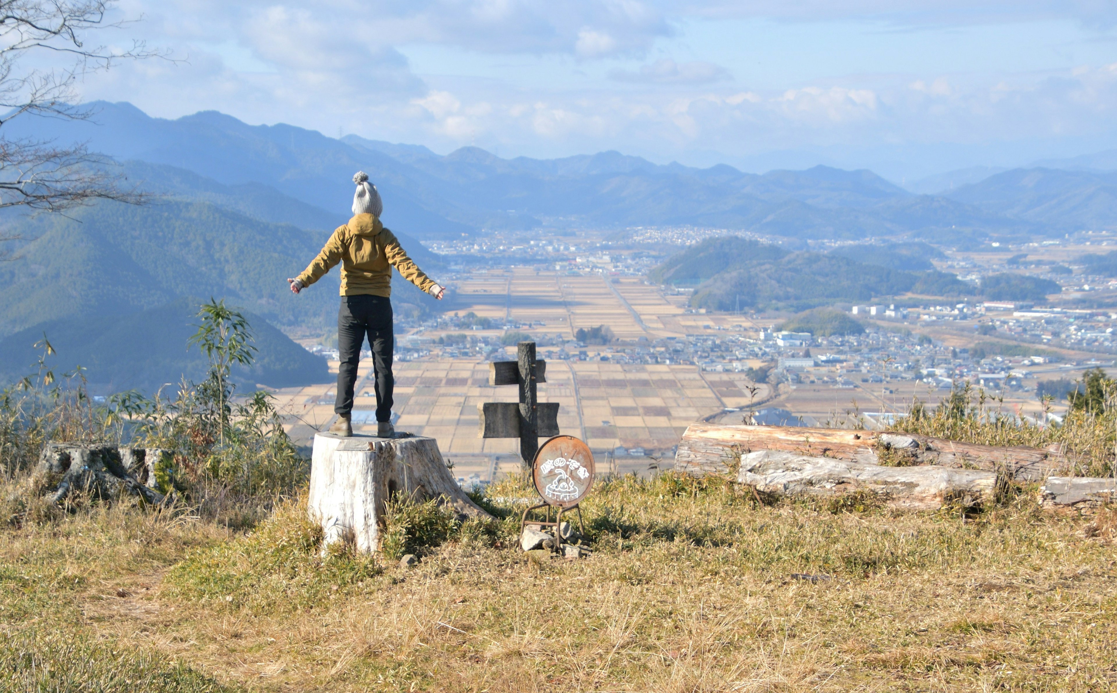 Una persona de pie en la cima de una colina que observa un vasto paisaje