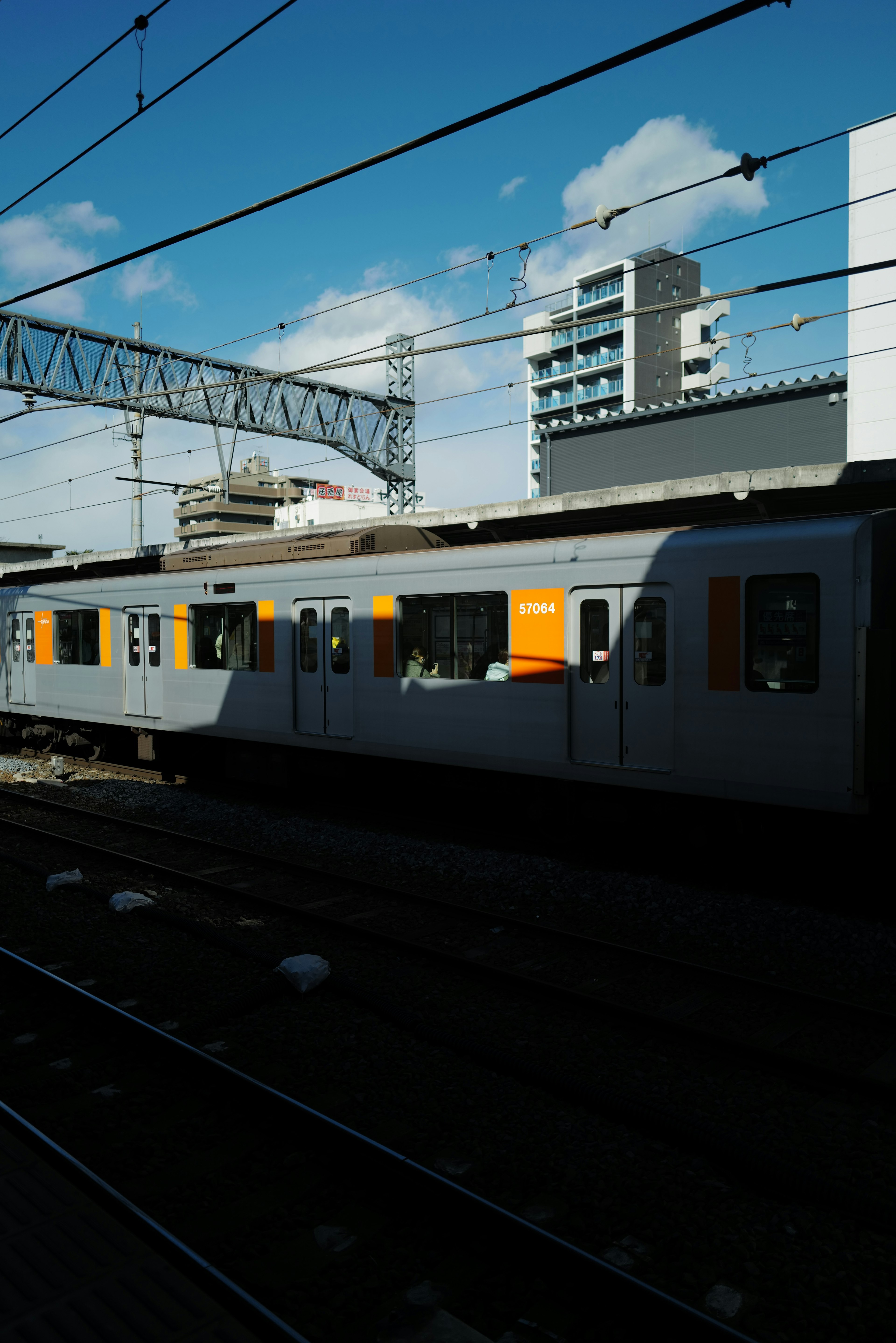 Treno arancione in stazione con cielo azzurro