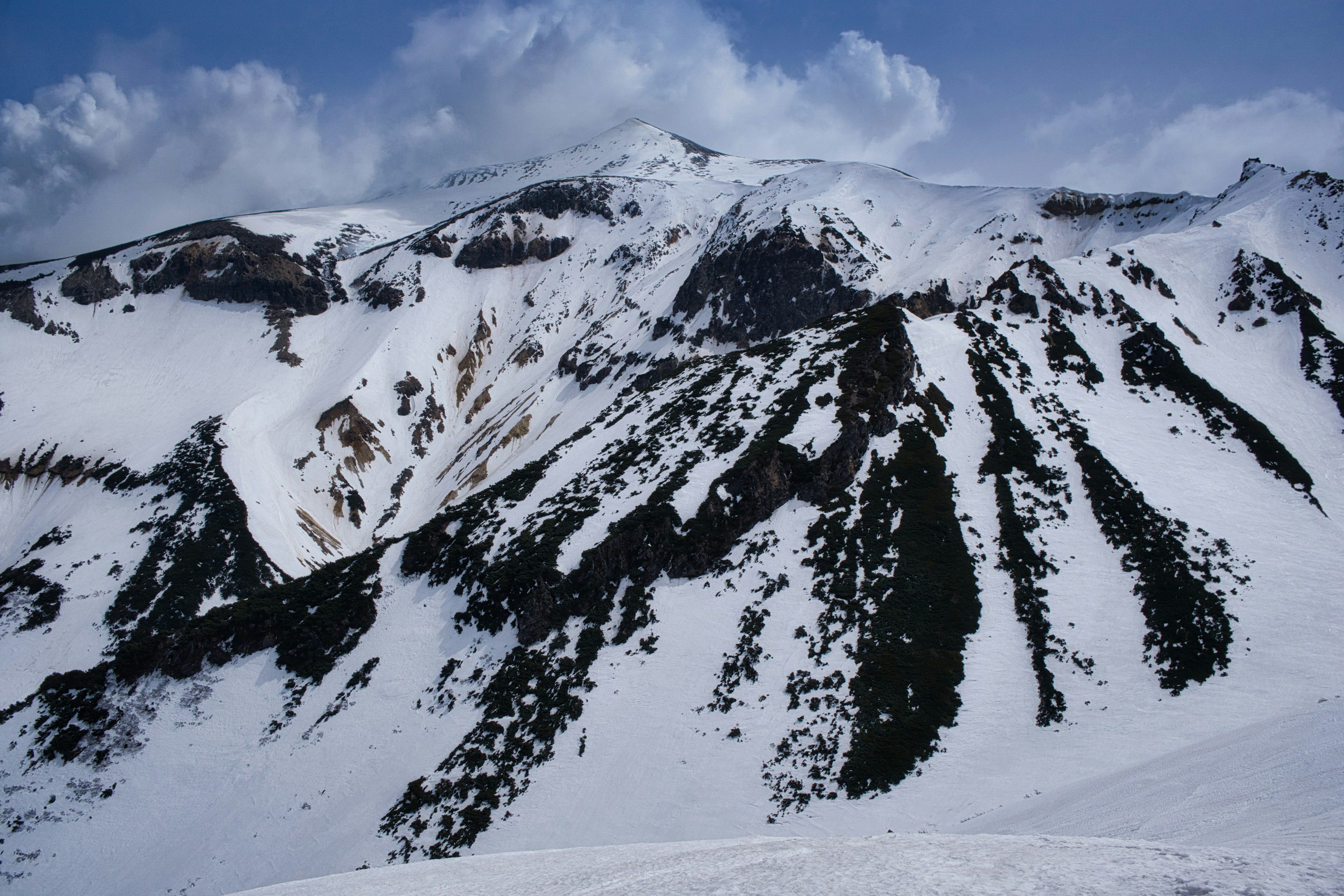 Snow-covered mountains under a blue sky