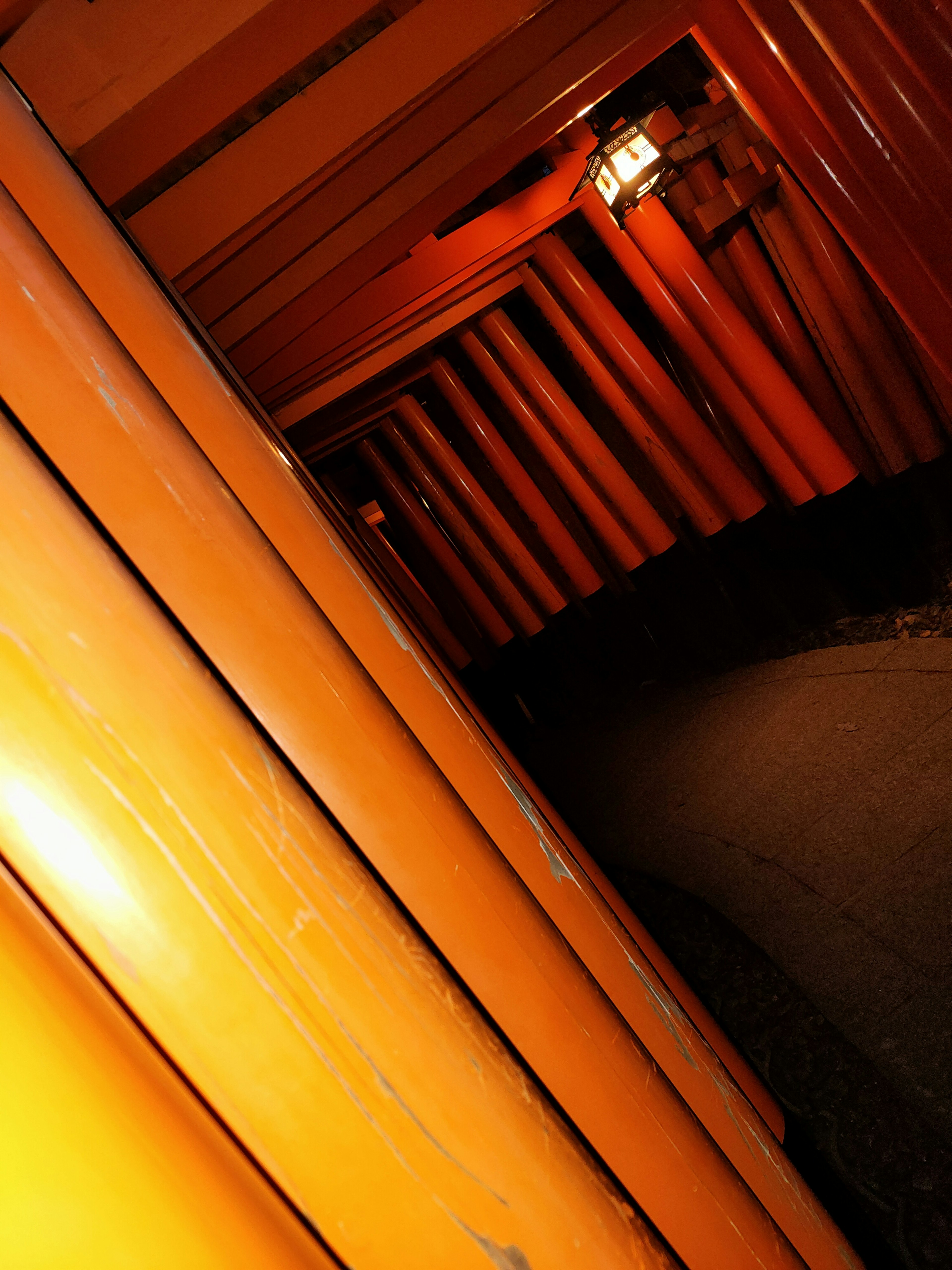 Interior view of an orange tunnel with vertical pillars