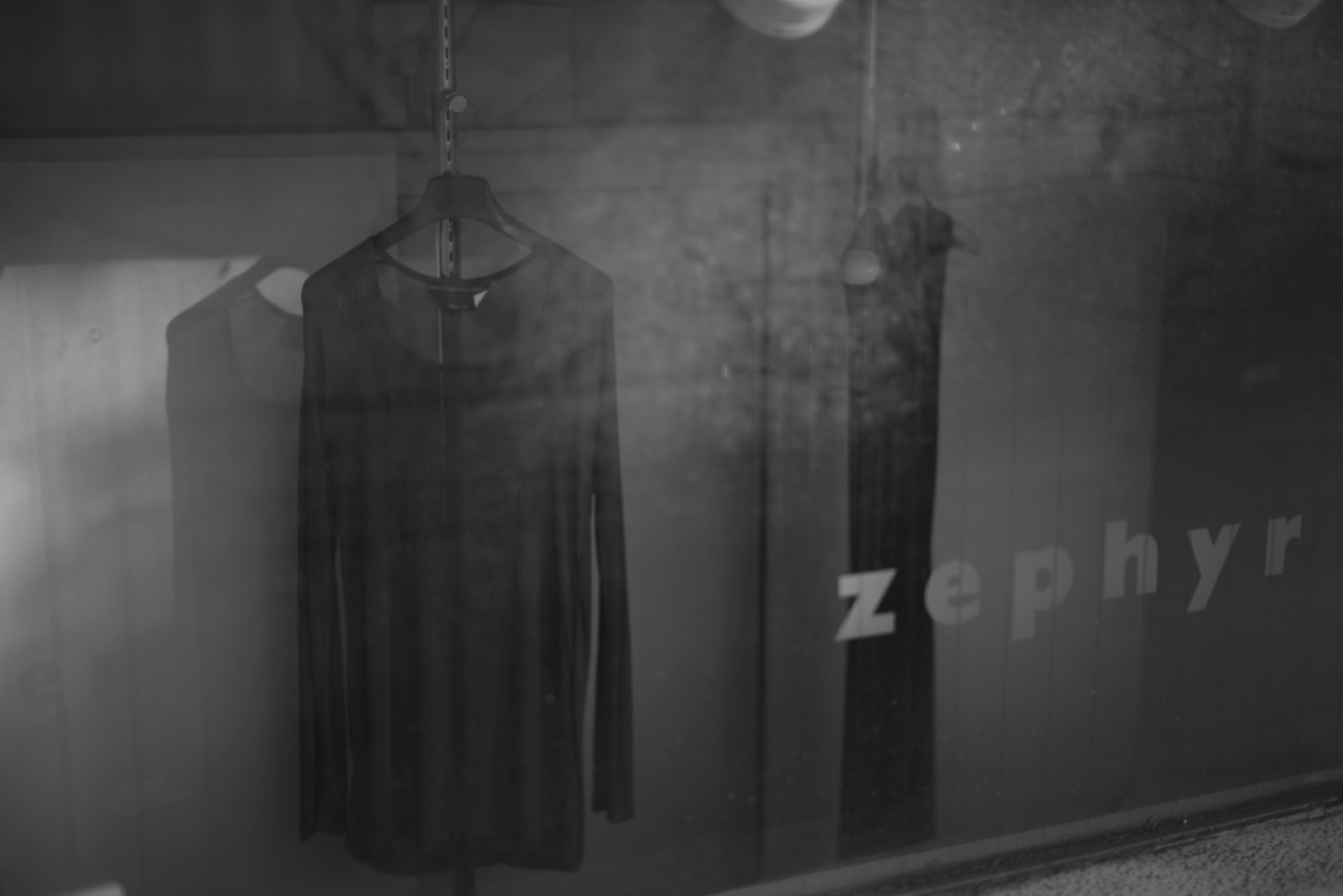 黒い服がハンガーに掛かっている店内の写真 ゼファーの文字が見える