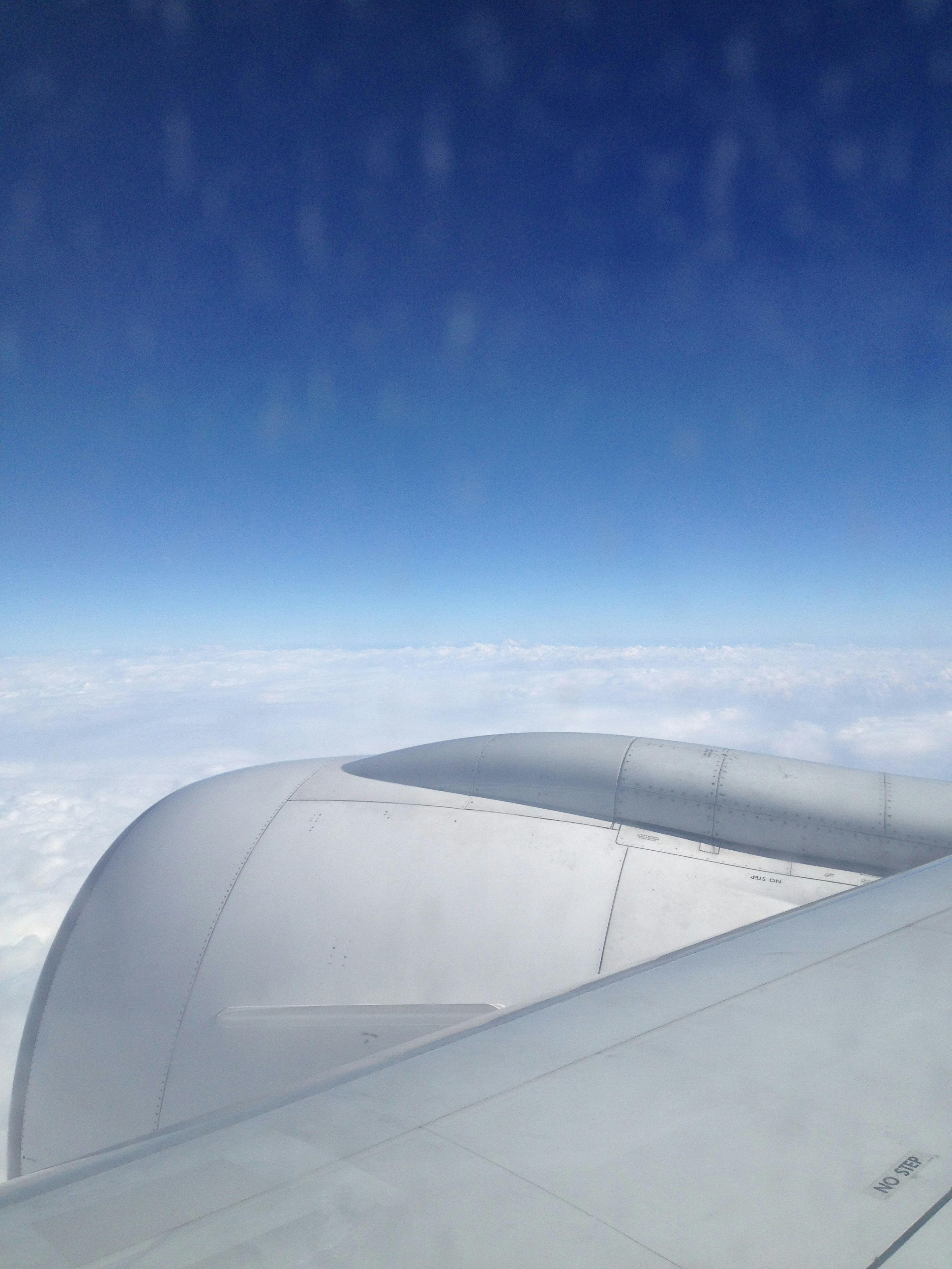 View of an airplane wing against a clear blue sky