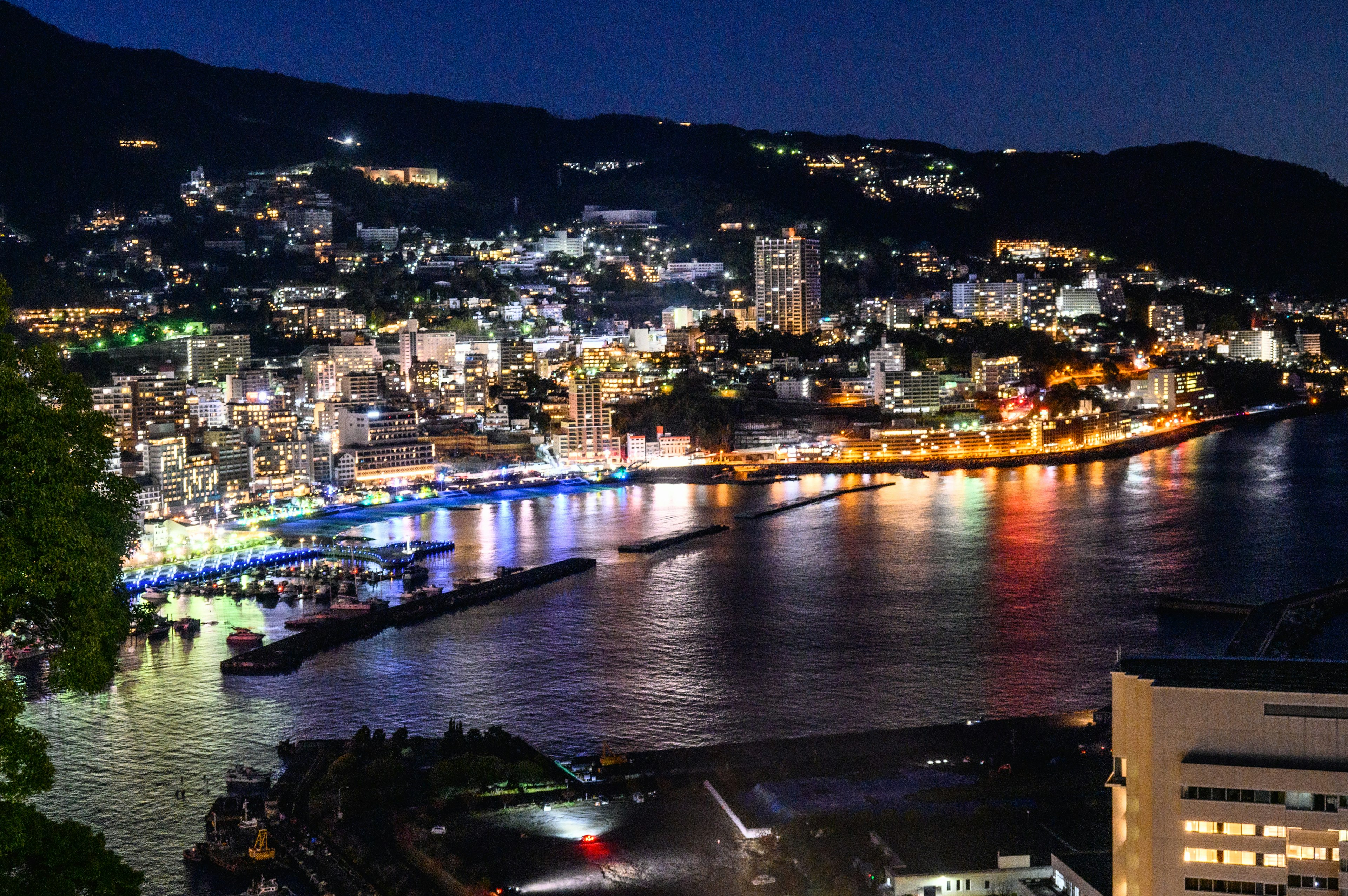 夜景の都市風景 明るい光と川の反射