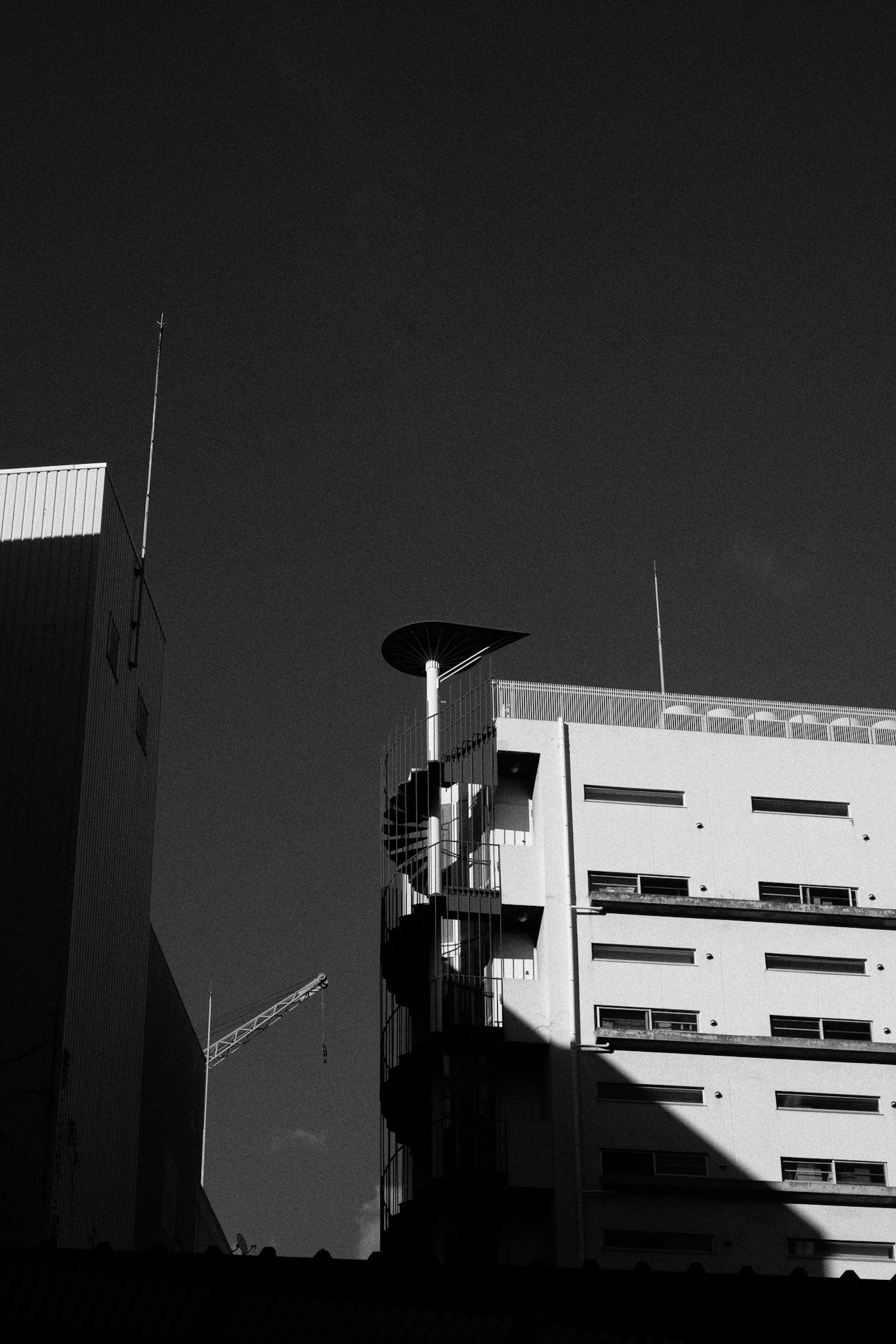 白黒の建物と螺旋階段の構造が見える都市の風景