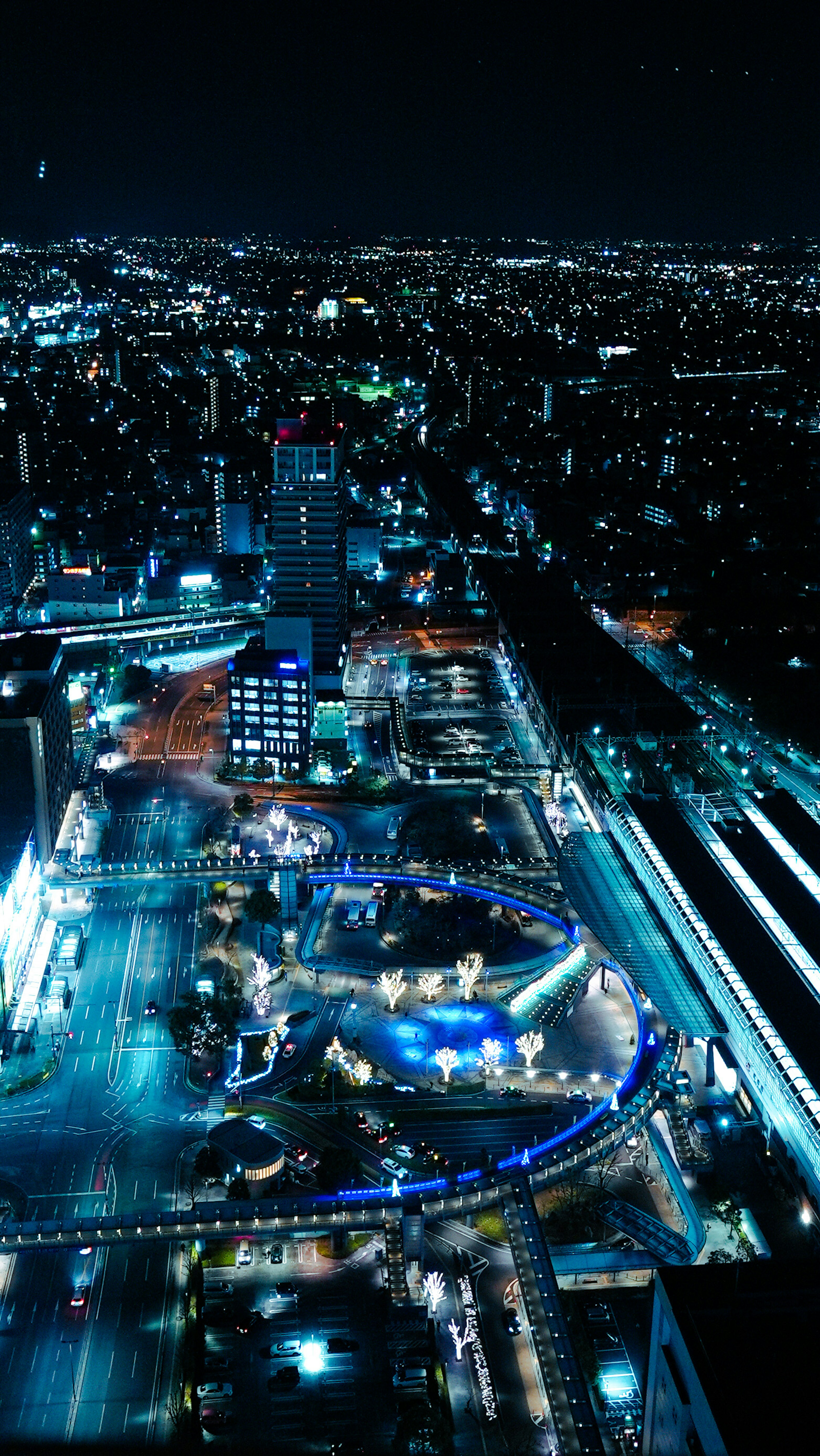 Vue aérienne d'une ville animée la nuit avec des bâtiments et des rues éclairés