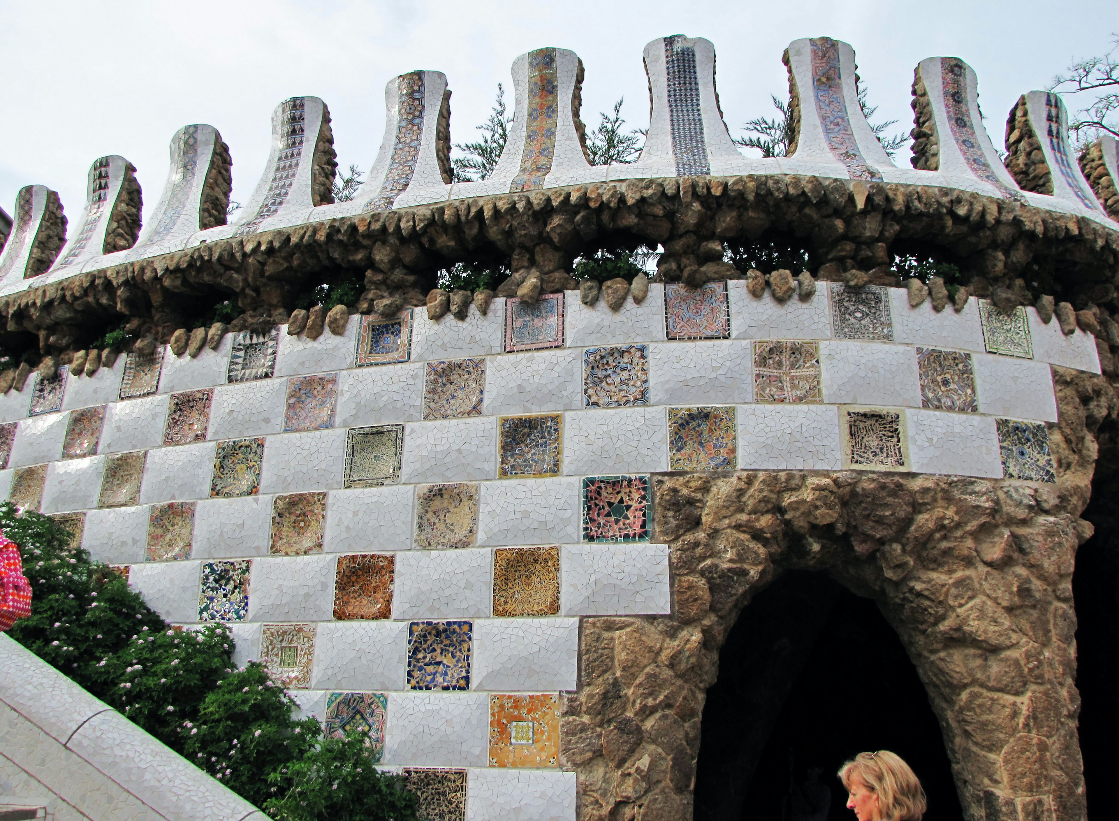 Exterior of Gaudi's Park Guell building featuring white and colorful tile decoration