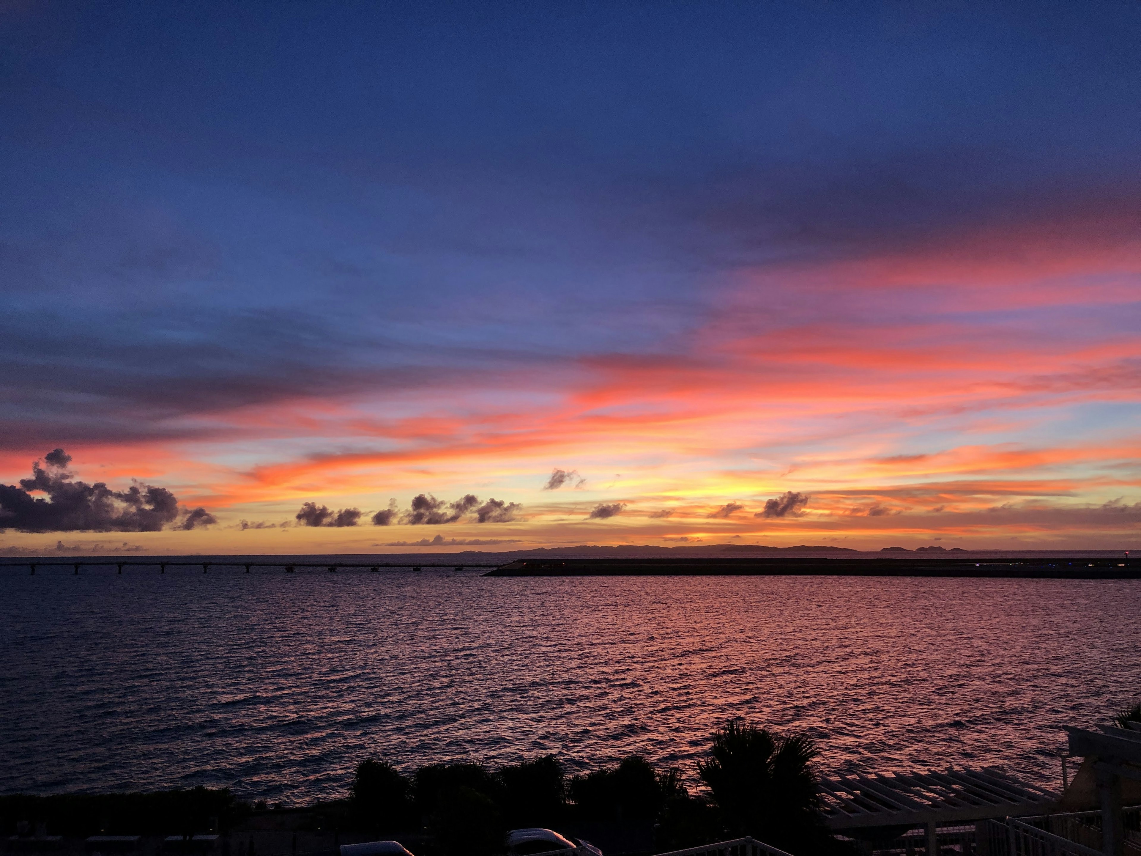 Pemandangan matahari terbenam yang indah di pantai dengan warna langit yang cerah