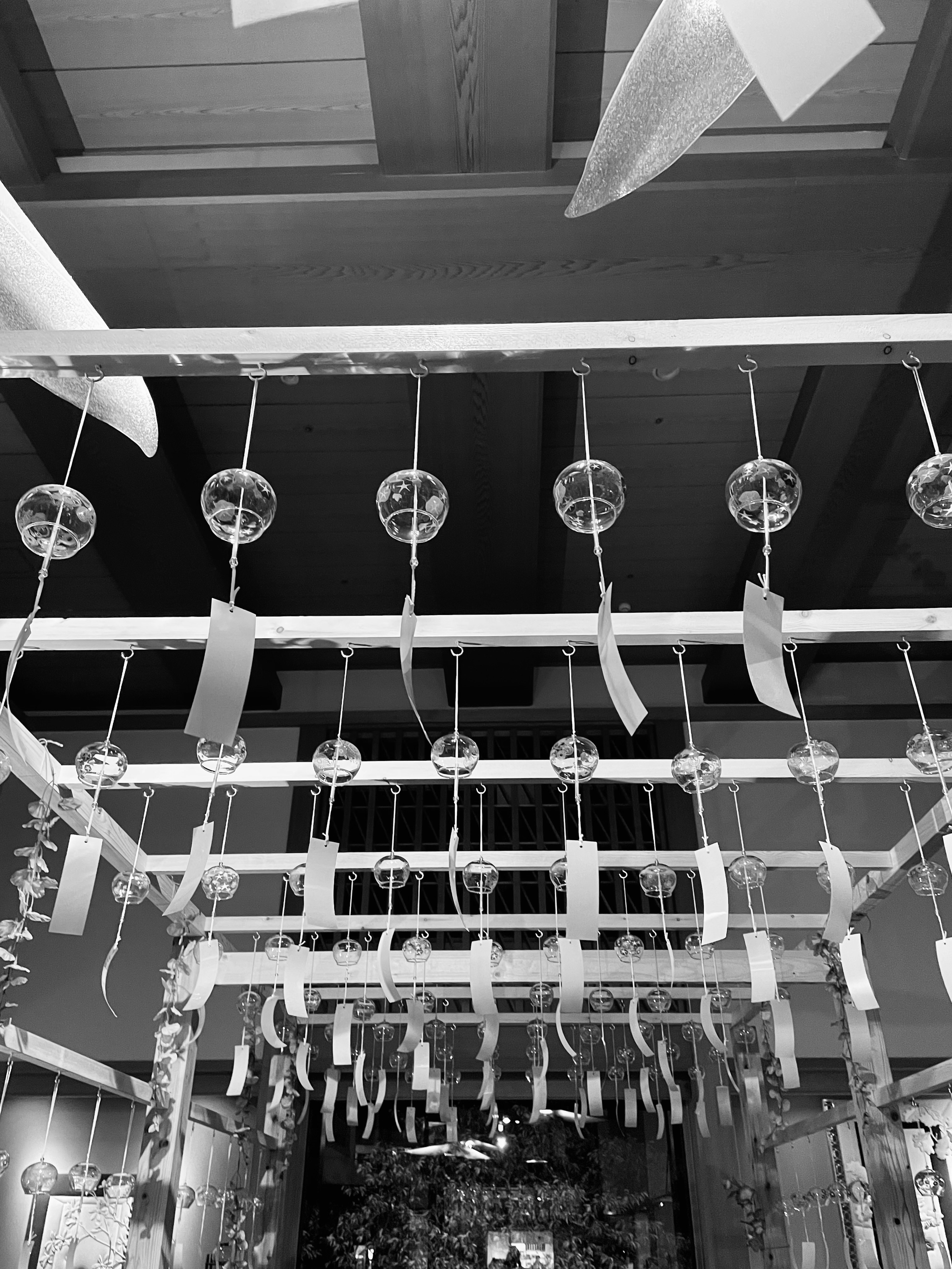 Indoor scene with hanging wind chimes and tanzaku in black and white