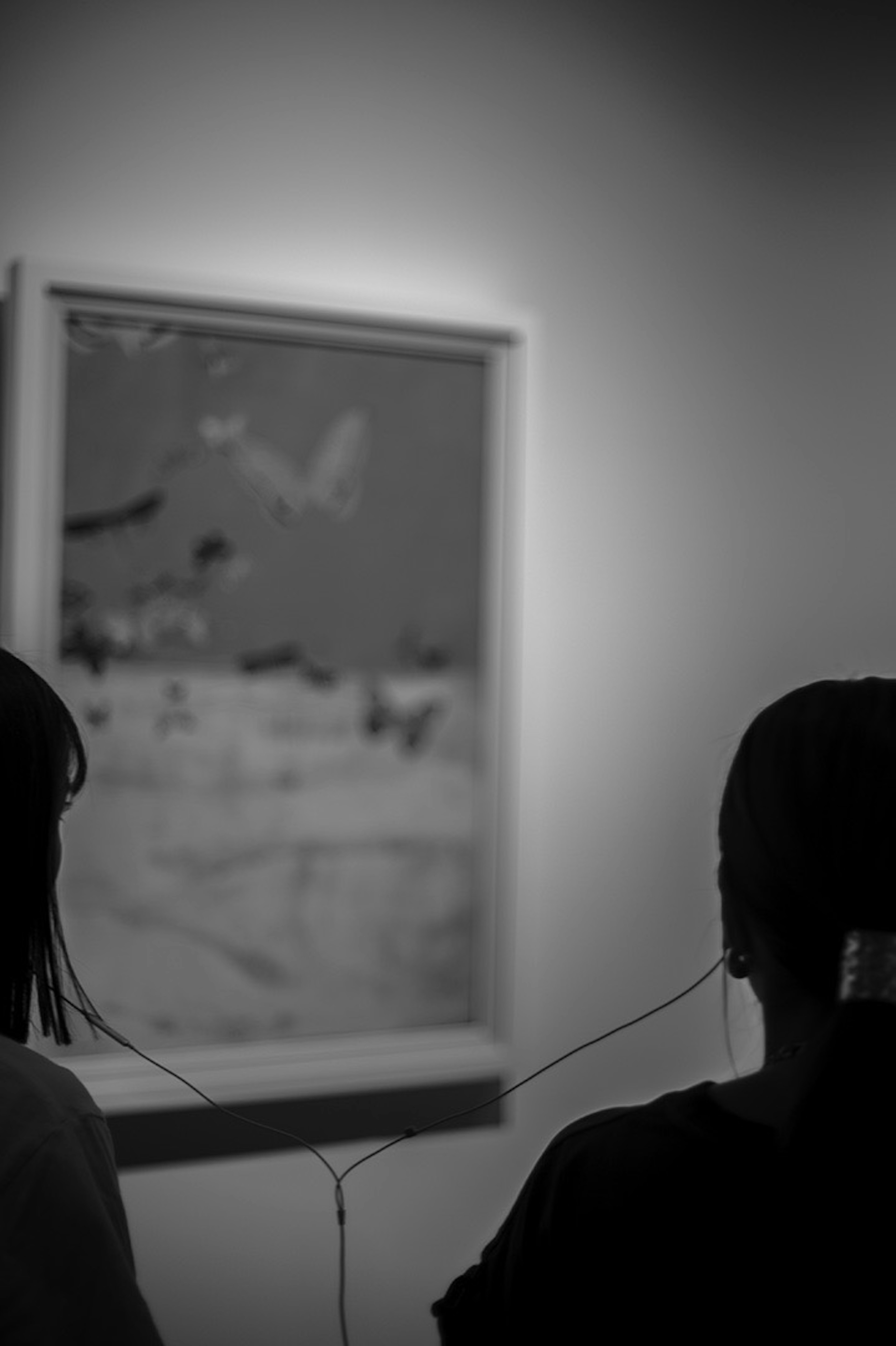 People viewing a painting in an art gallery