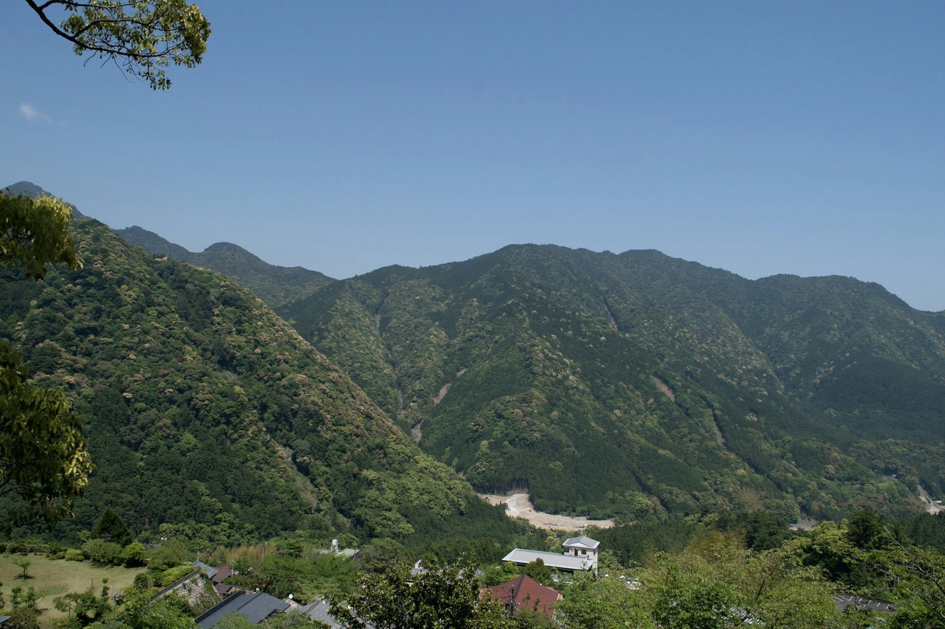 Vue panoramique de montagnes verdoyantes sous un ciel bleu clair